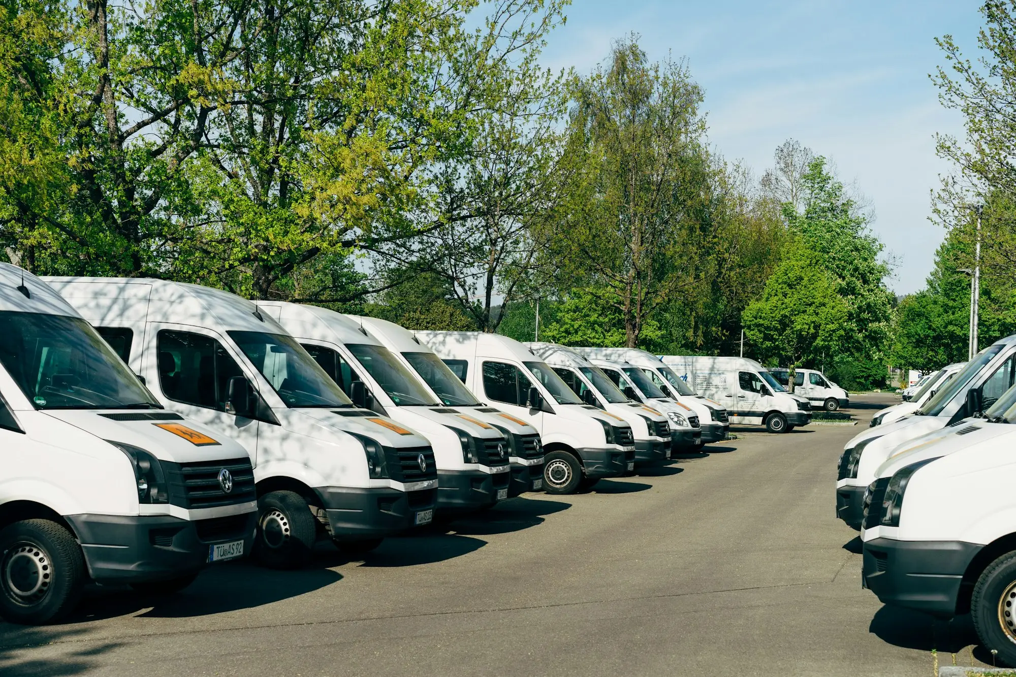Fleet of white vans parked in a row, business assets funded with asset finance