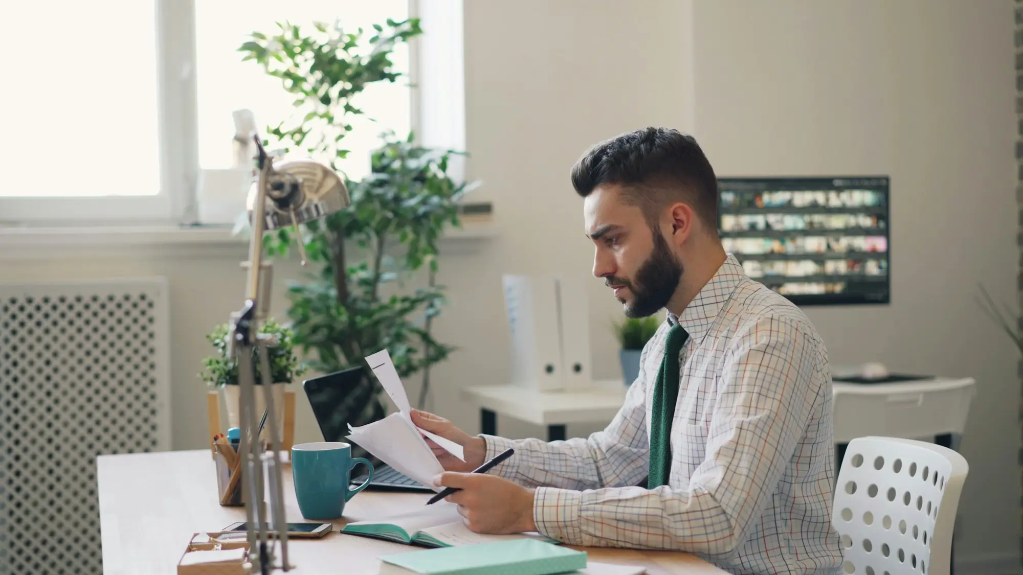 Small business owner reviewing an ATO payment plan statement at a desk before consolidating business debts
