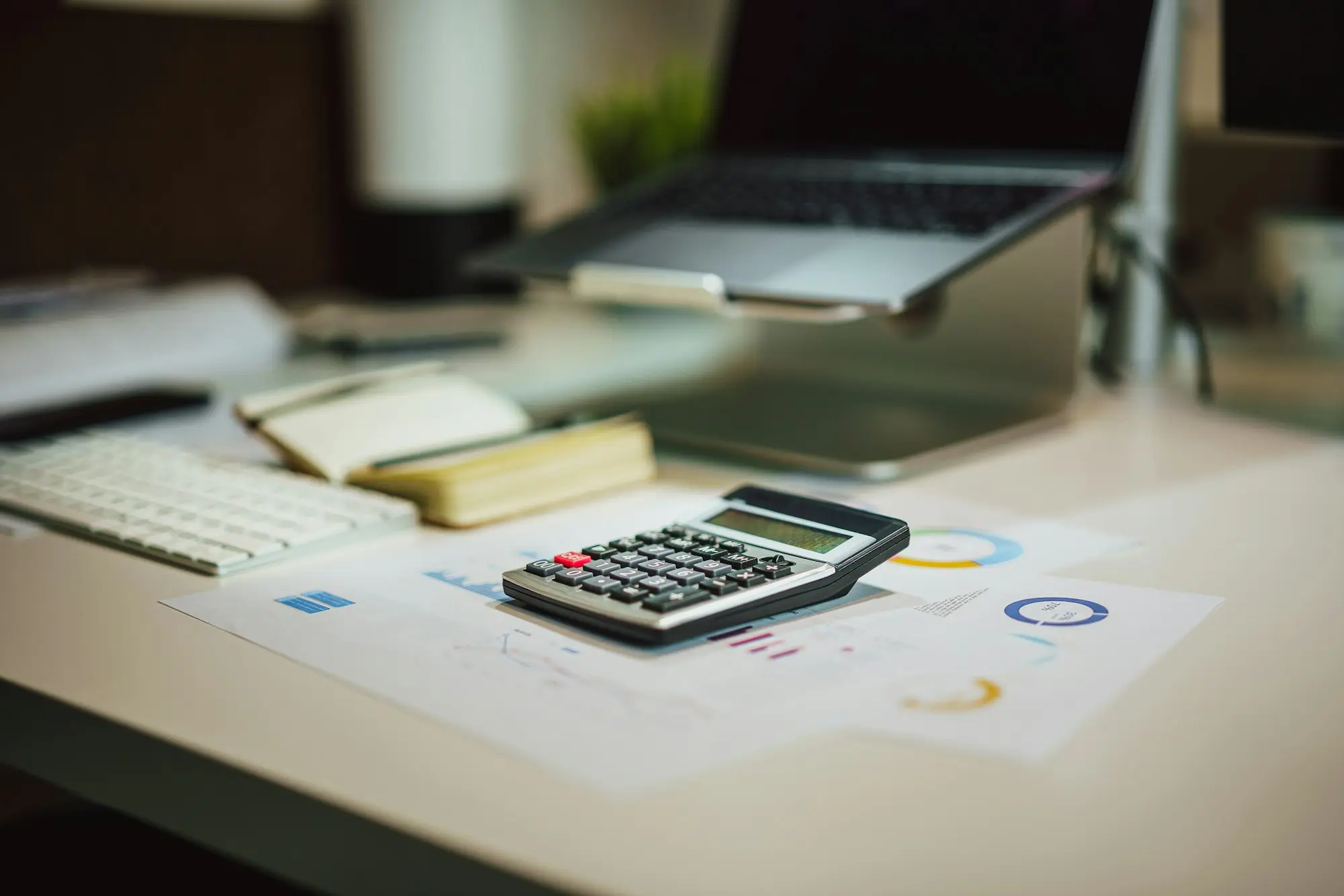 Tax paperwork and a calculator on a desk while an owner works out an ATO debt