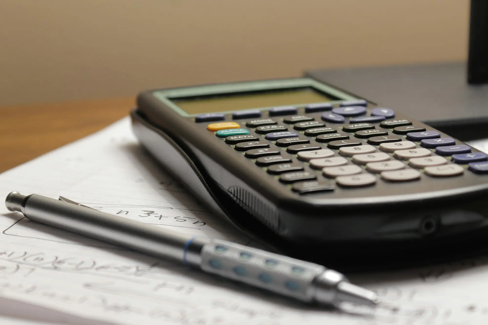 Calculator and financial documents spread out while reviewing business debts to refinance
