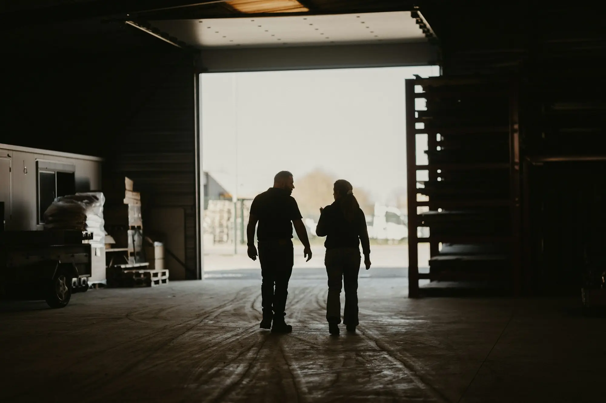 Father and adult daughter in the family workshop discussing buying the family business from her parents