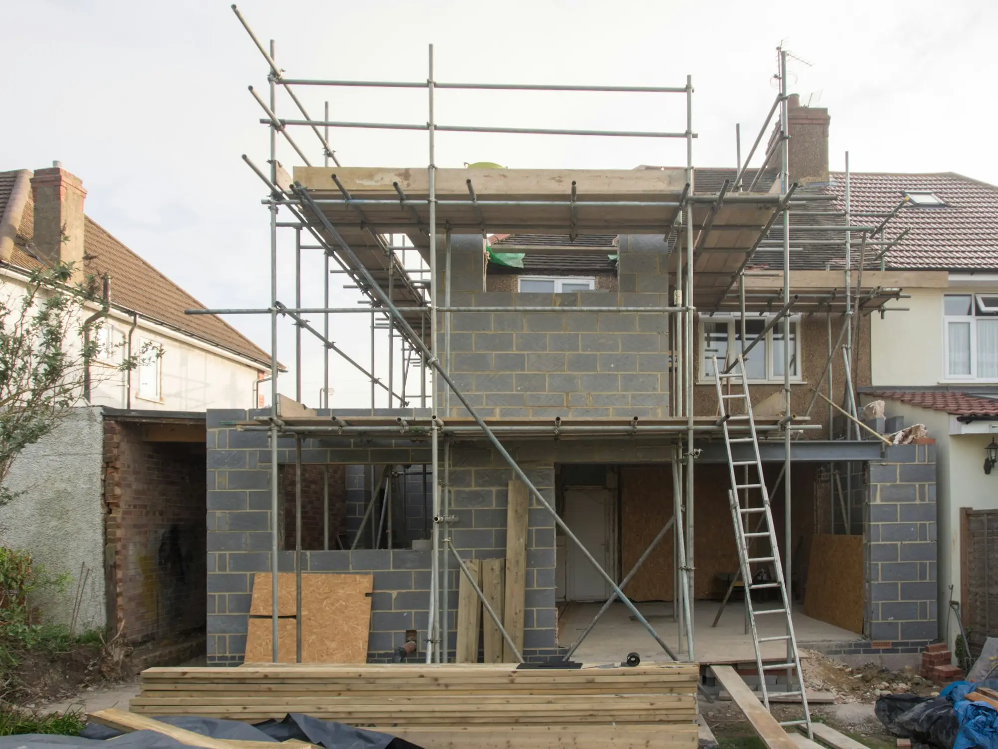 Unfinished townhouses wrapped in scaffolding as the construction loan approaches its expiry date and the developer seeks an extension