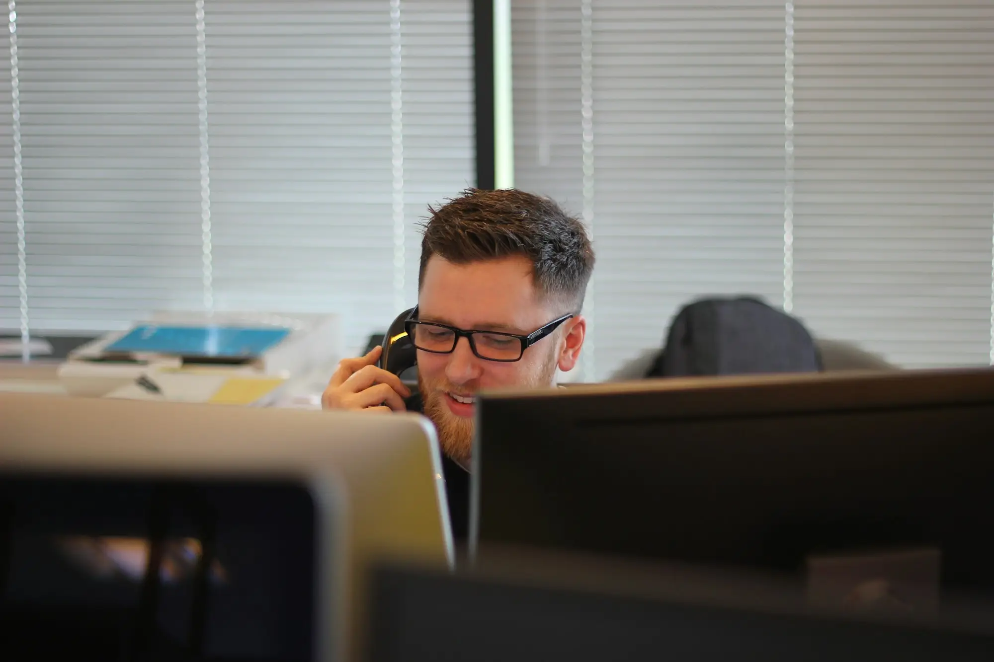 Small business owner on a phone call after a major customer entered administration with financed invoices outstanding