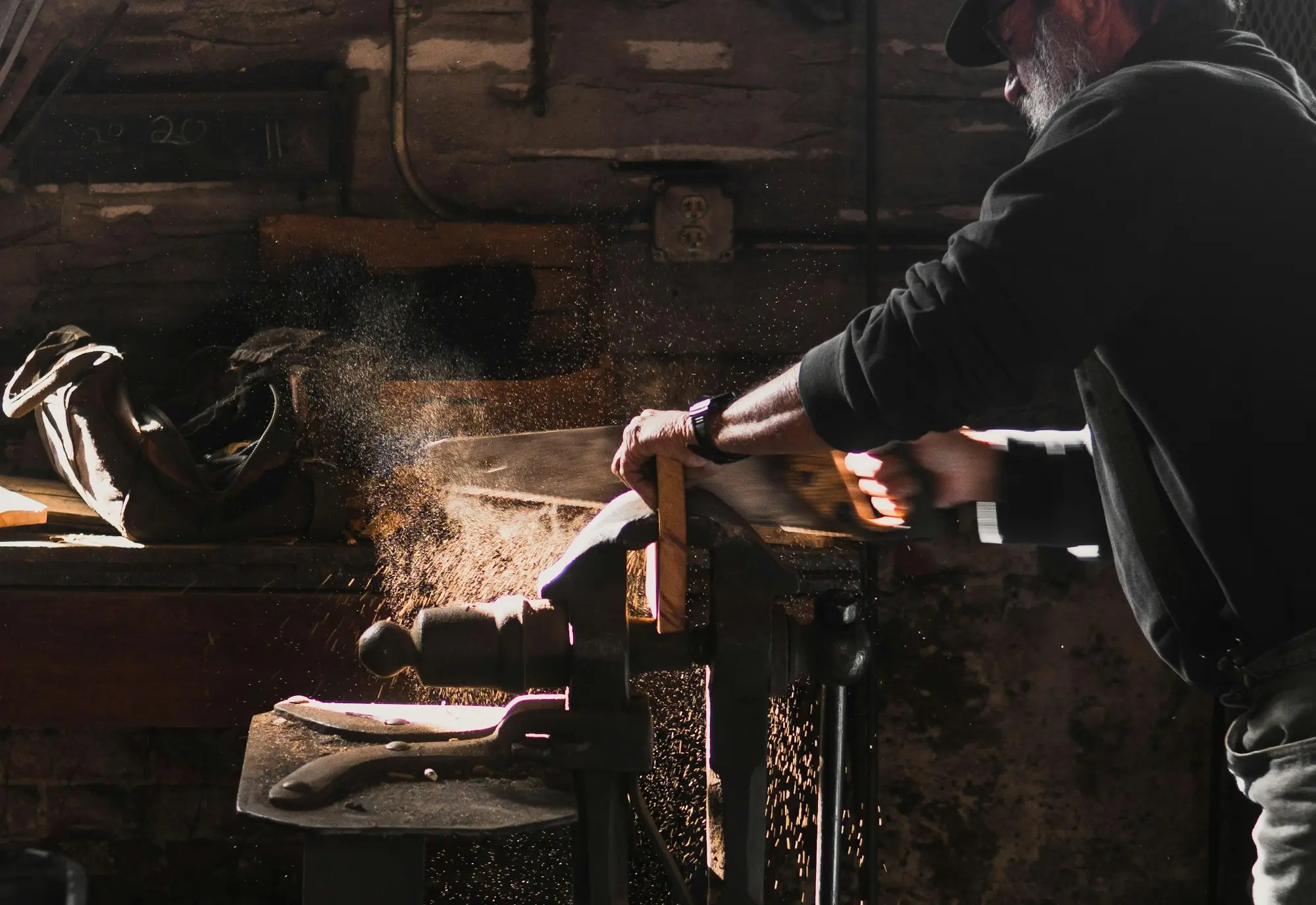 Carpenter cutting timber at a bench in a joinery workshop