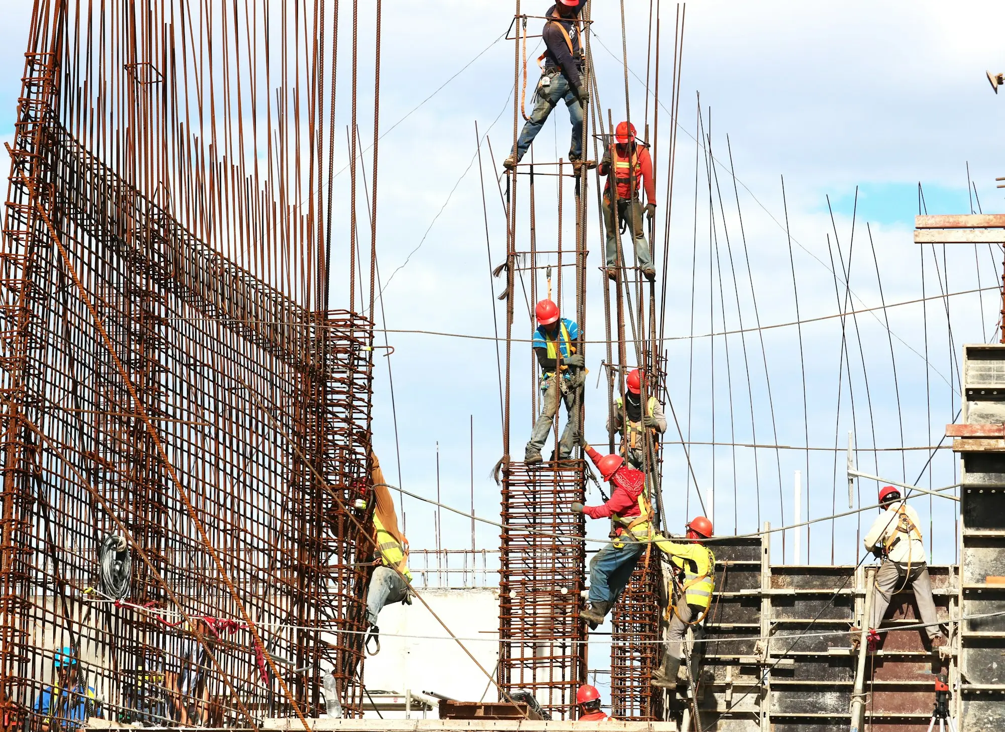 Concreting crew levelling and finishing a freshly poured concrete slab on a building site