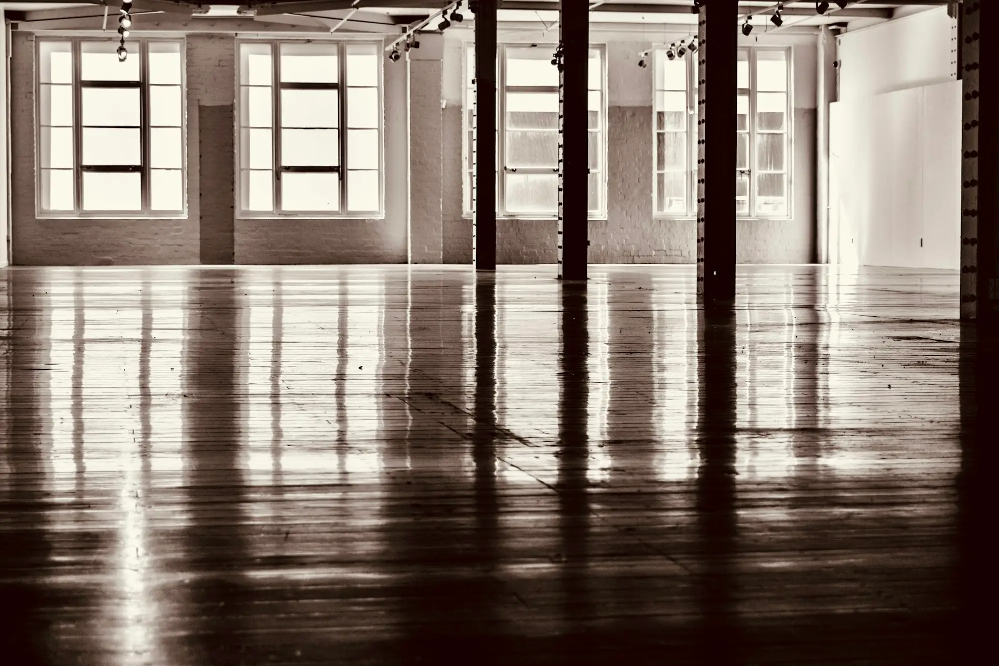 Empty dance studio with a timber sprung floor, barres and wall mirrors
