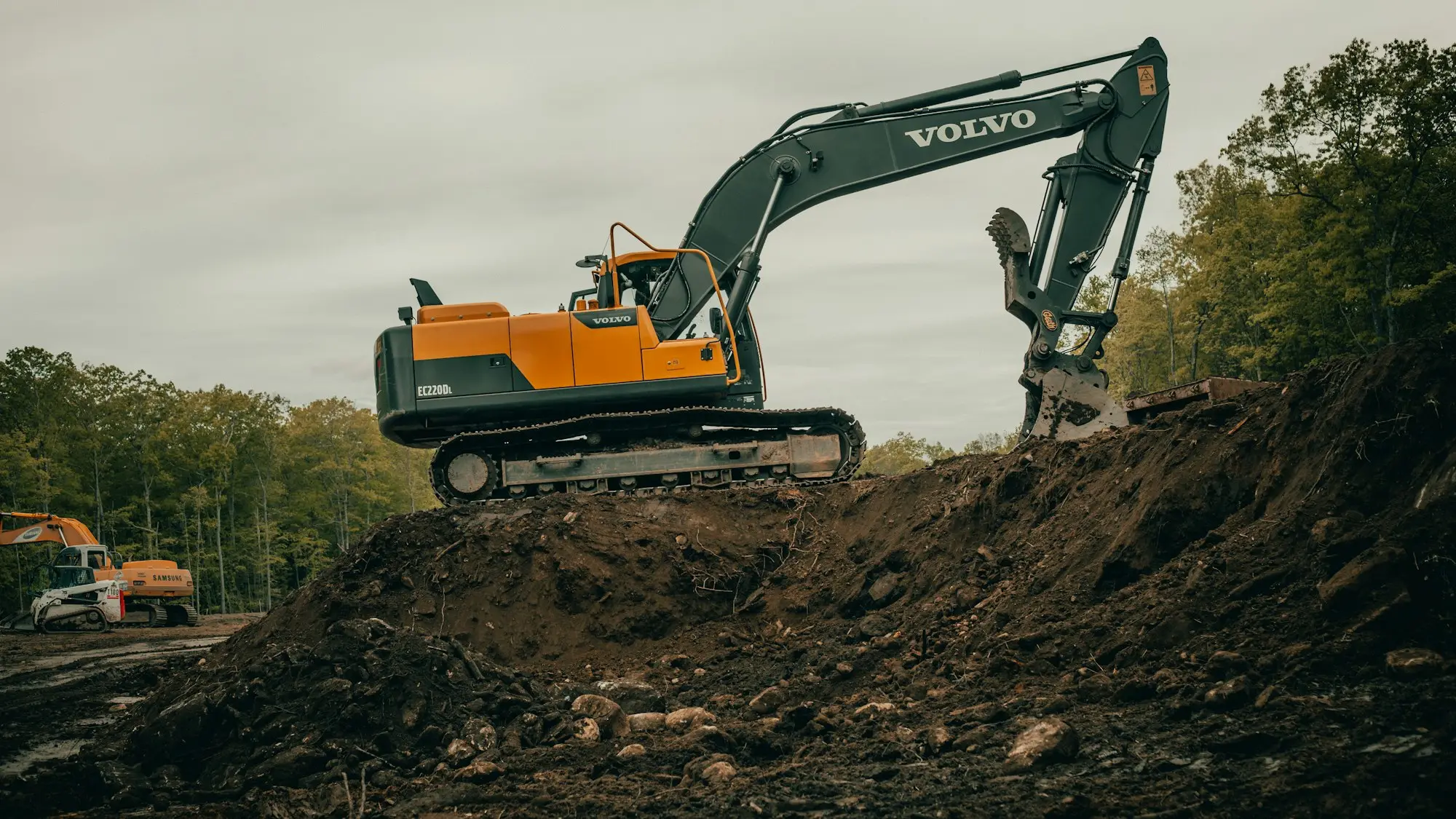 Excavator digging and loading soil on a building site during earthworks