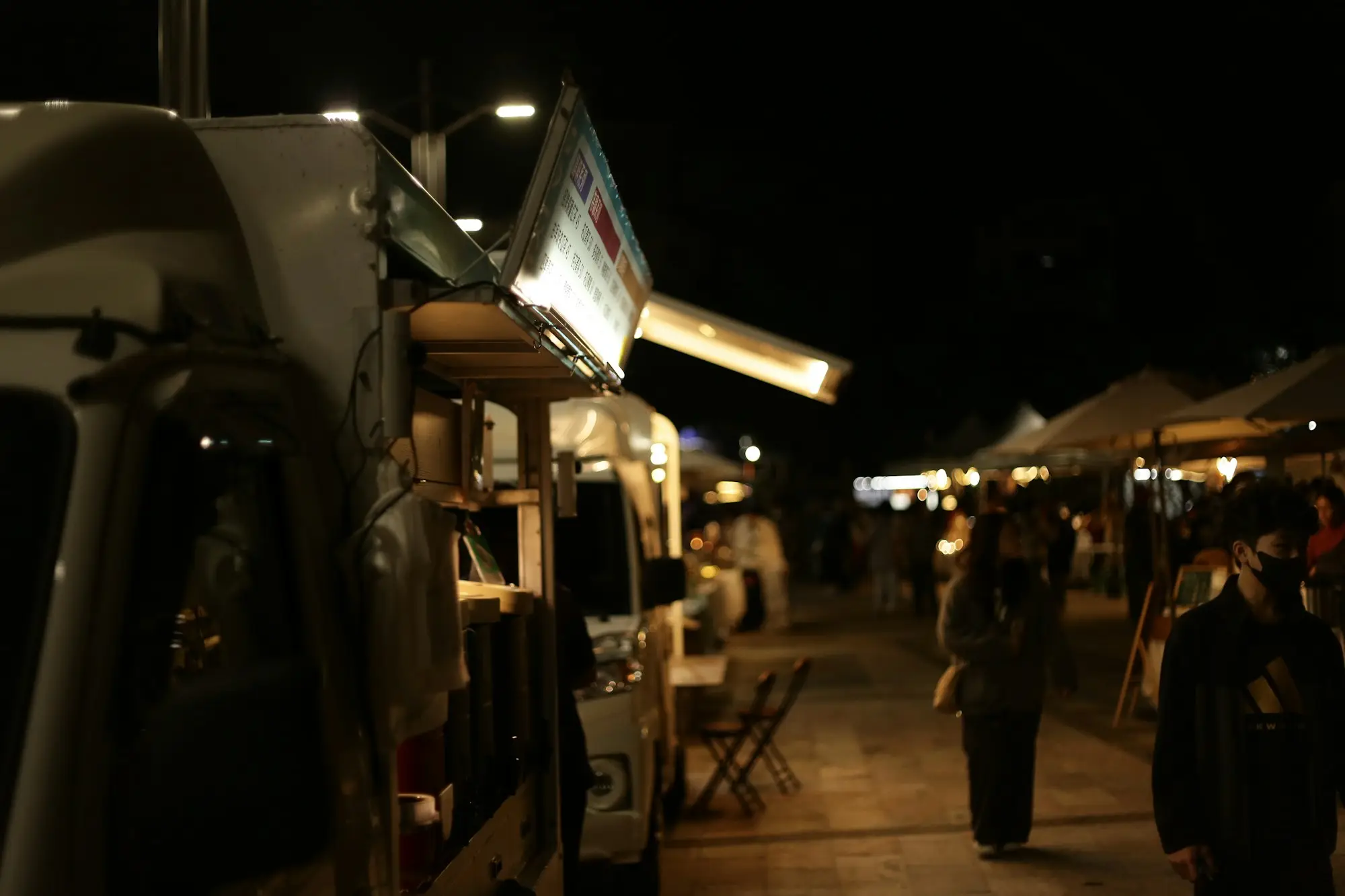 Food truck serving customers at a busy night market