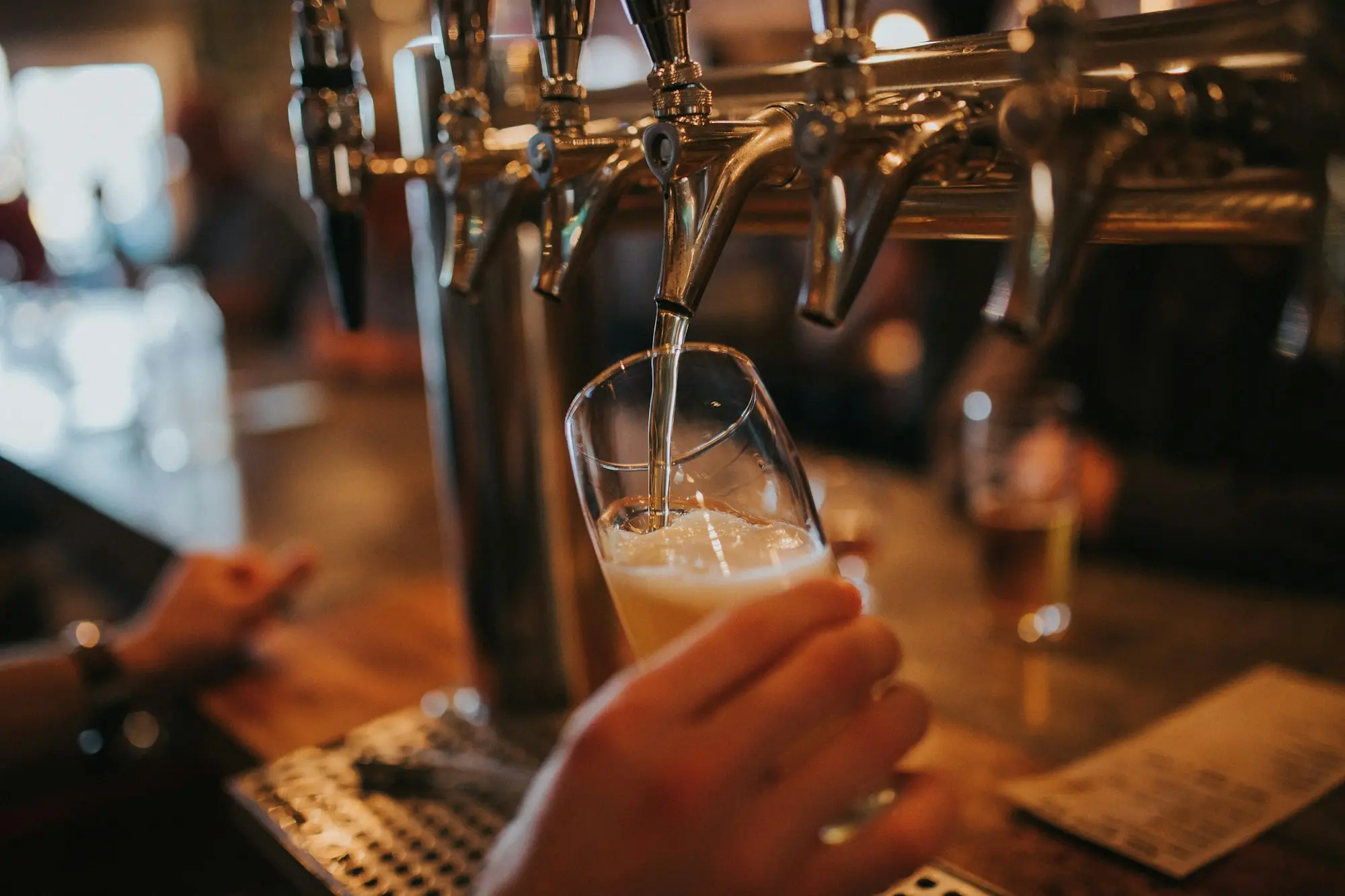 Bartender pouring a beer from the taps at the front bar of an Australian pub
