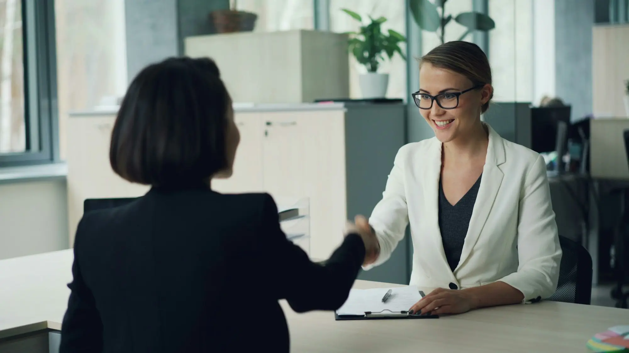 Recruitment consultant interviewing a candidate in a small office