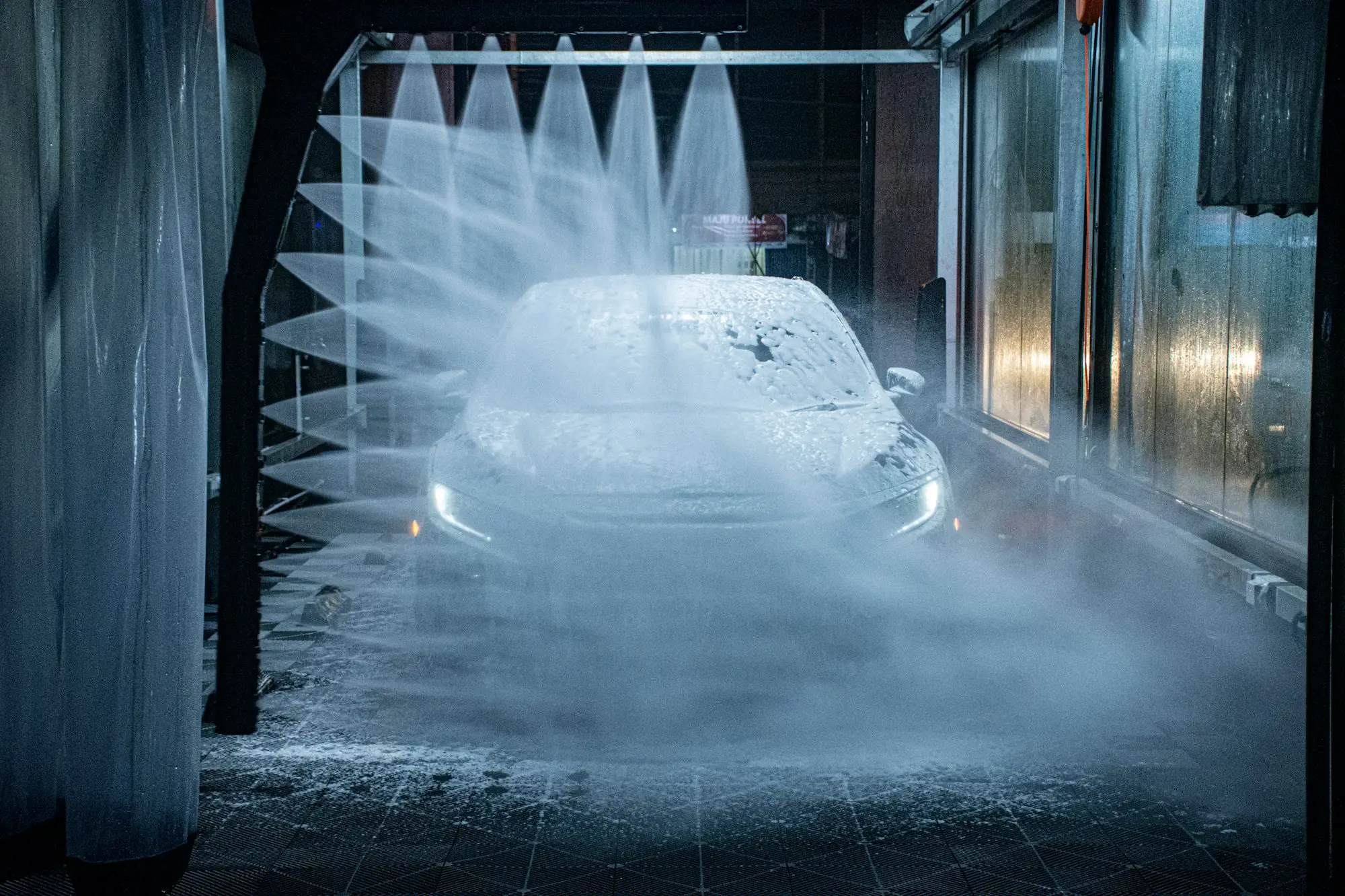 Smash repairer preparing a car in a spray booth at a panel beating workshop