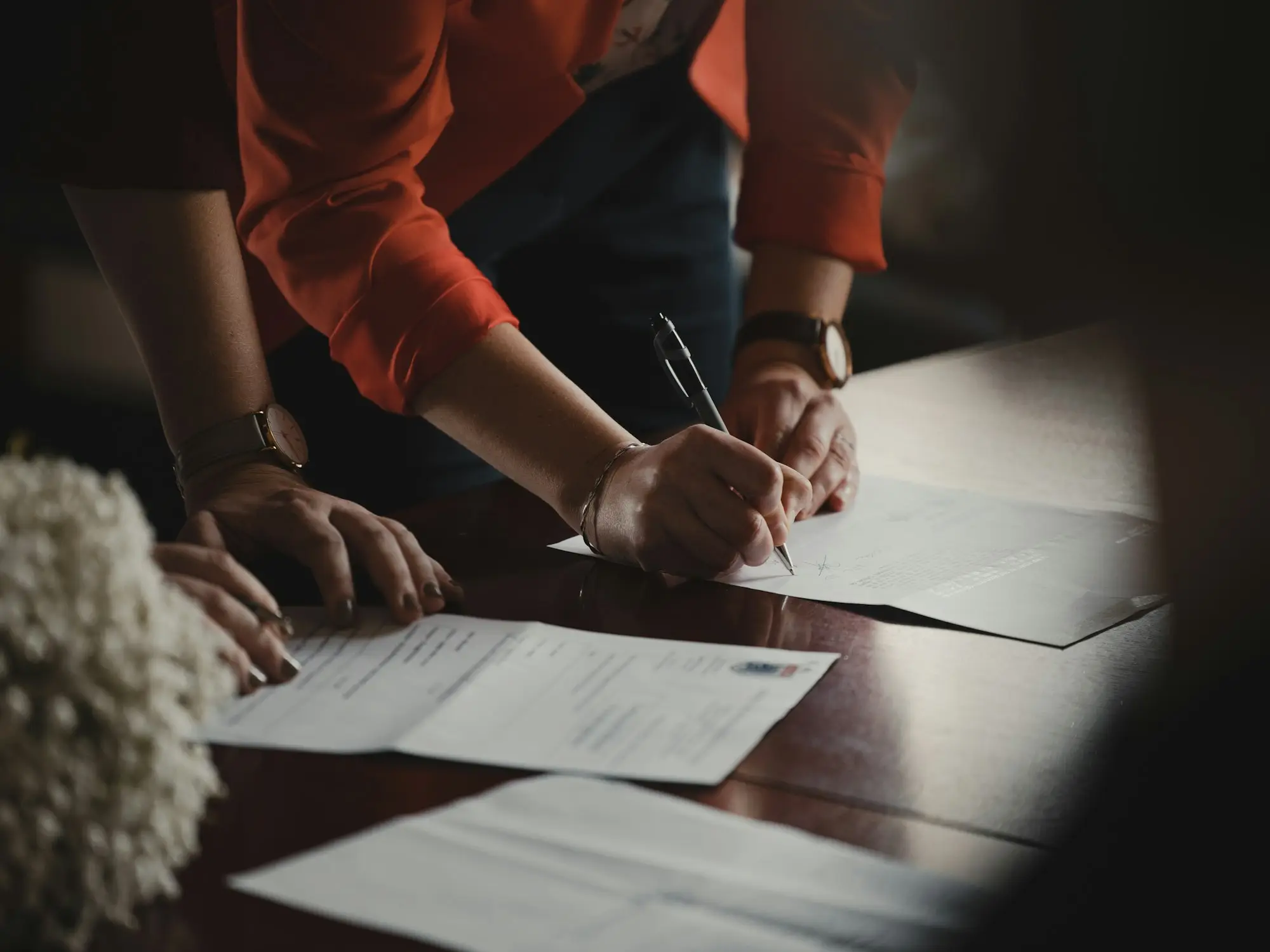 Company director signing payout documents to exit a debtor finance facility and refinance