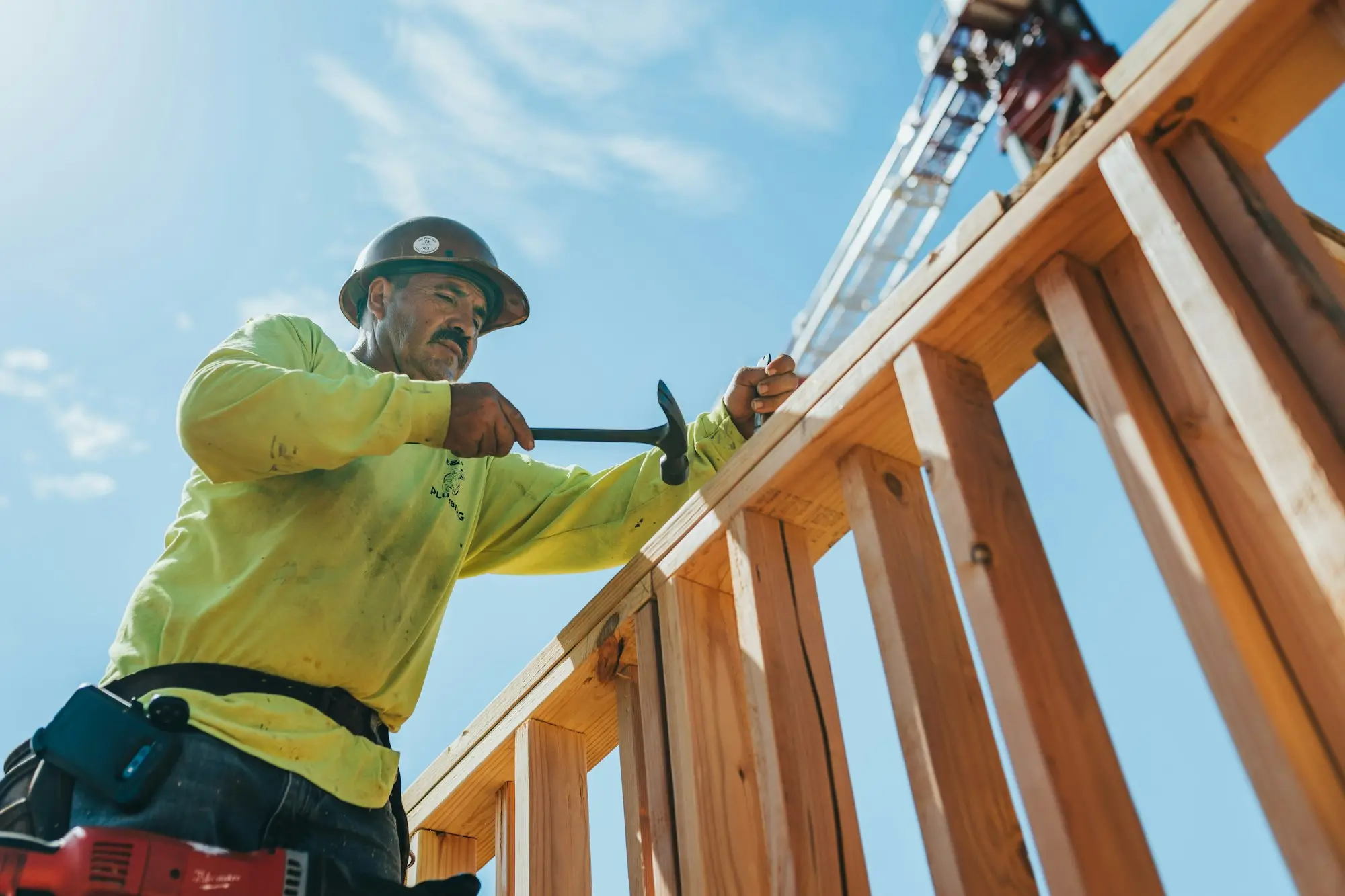 Builder on a fit-out site checking supplier invoices against plans after material costs pushed a fixed-price job over budget