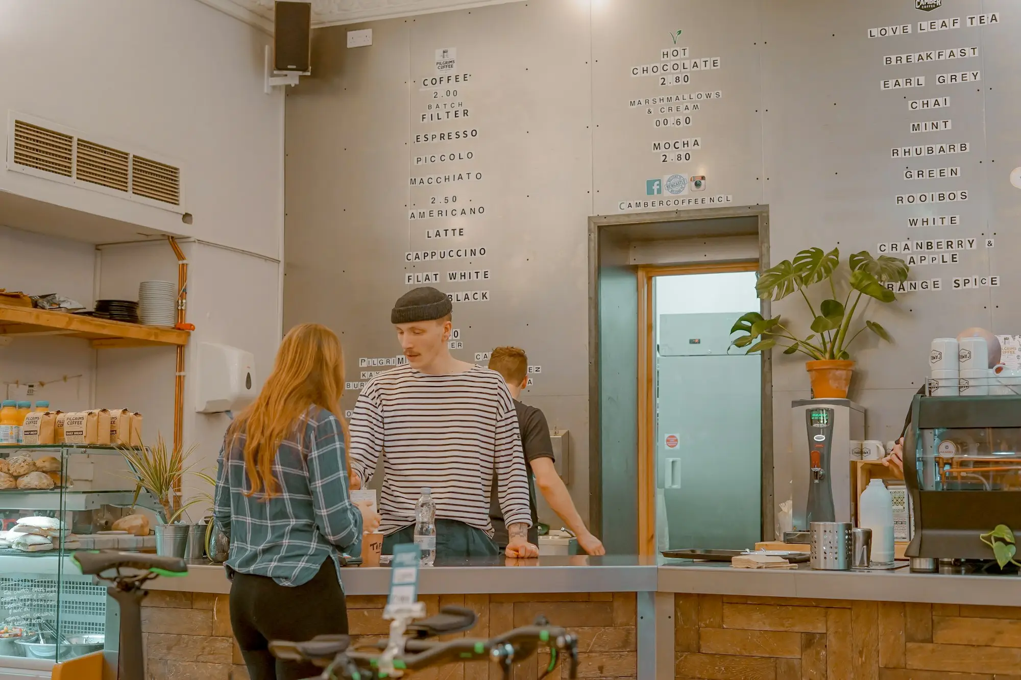 Staff serving customers at a busy café counter, a franchise owner's day-to-day