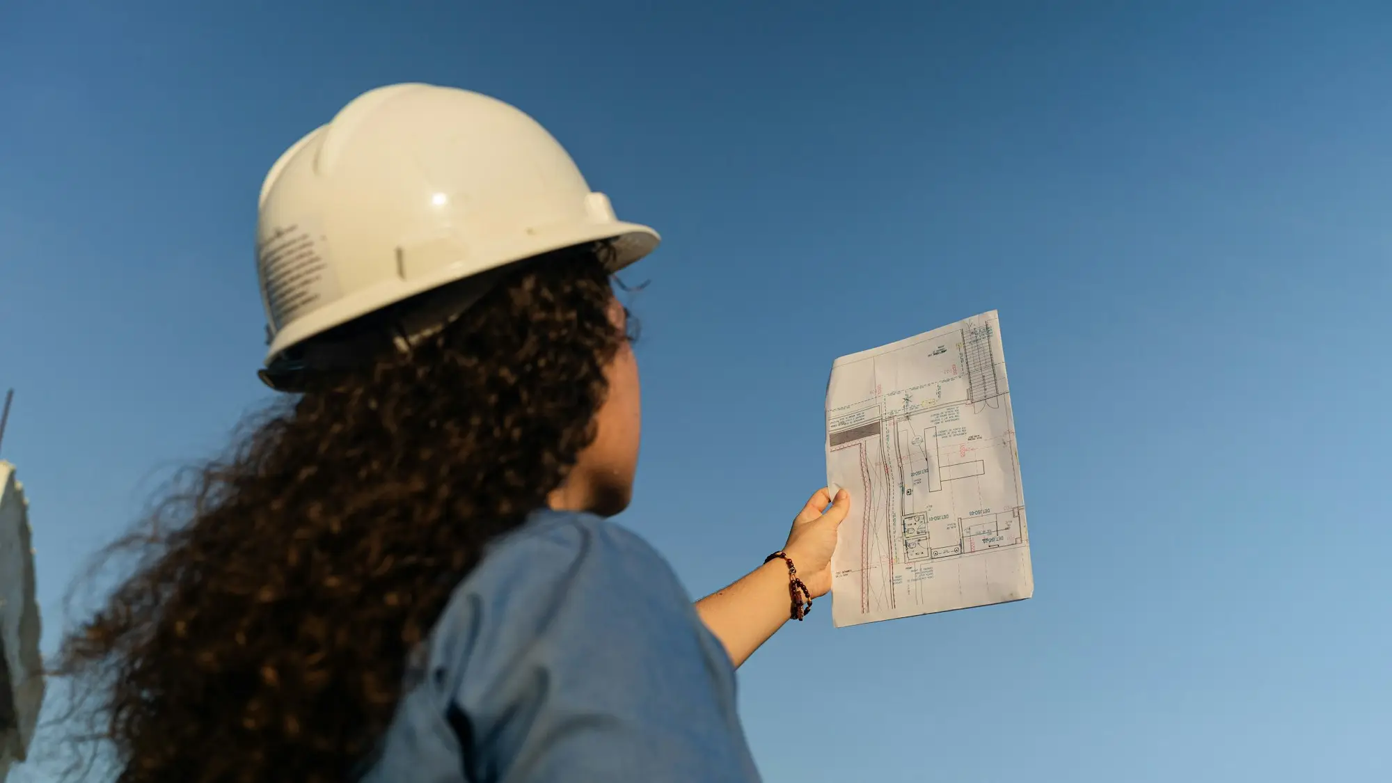 Builder checking a home warranty insurance certificate in a site office before the first construction loan draw on a residential job