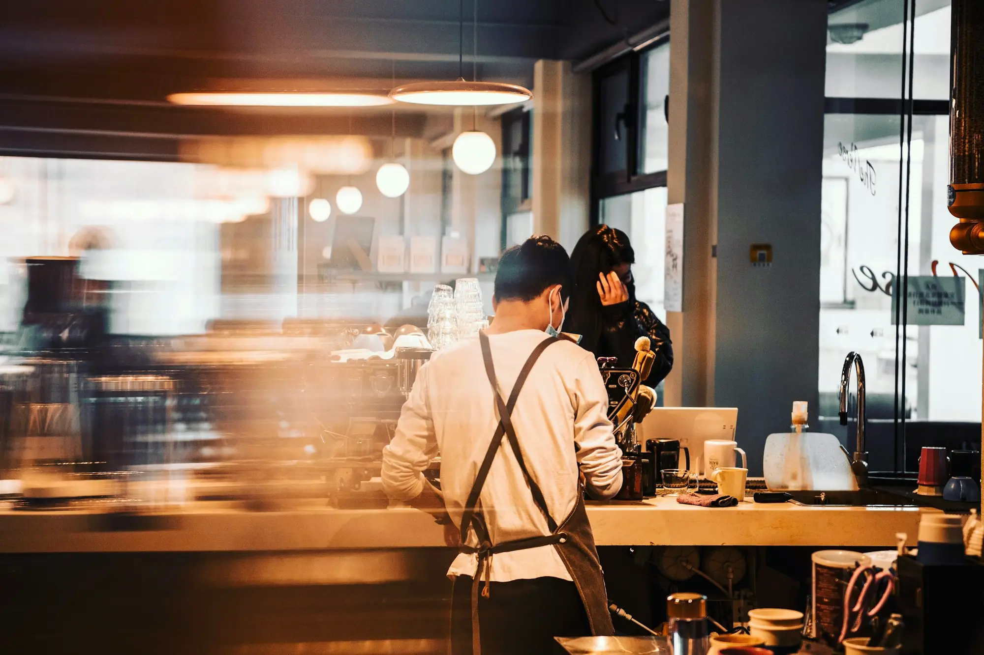 Café owner behind the counter at closing time, illustrating hospitality equipment finance with bad credit