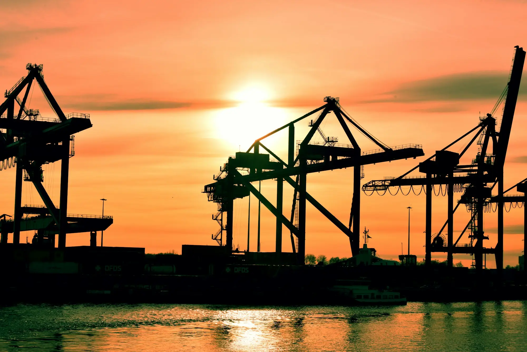 Container port cranes at sunset where imported goods land on import finance
