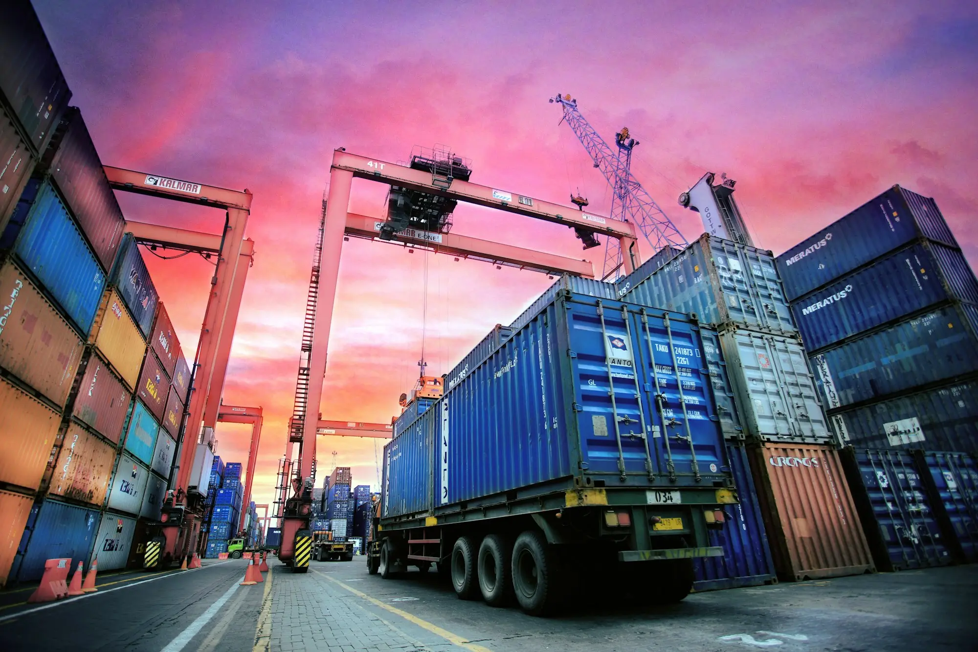 Stacked shipping containers waiting at a port, illustrating import finance when a shipment is held at the border