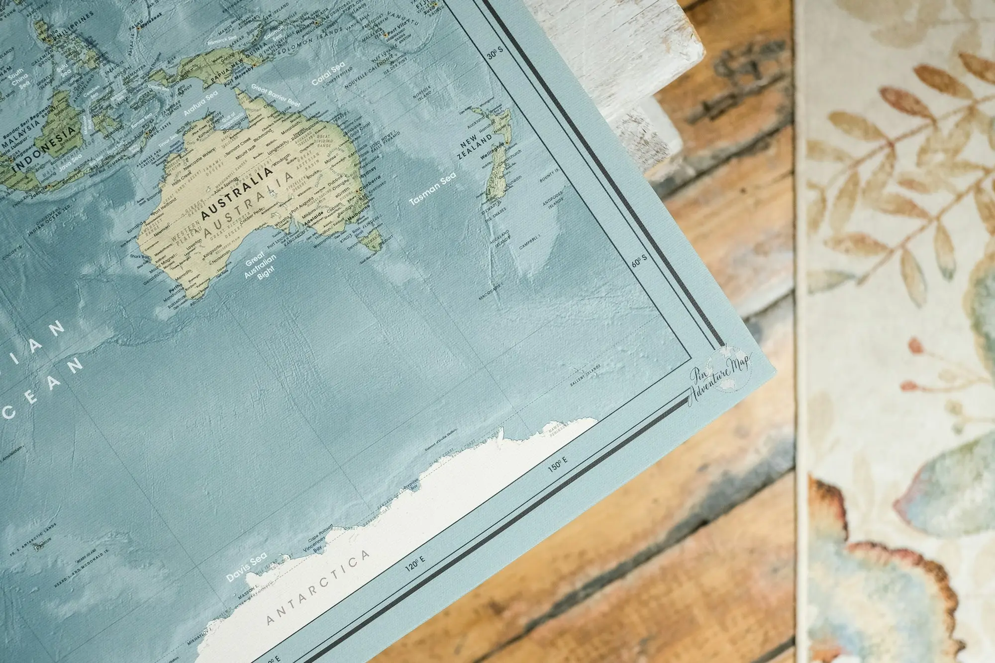 Business owner at a laptop with a map of Australia, planning to use interstate property as security for a business loan