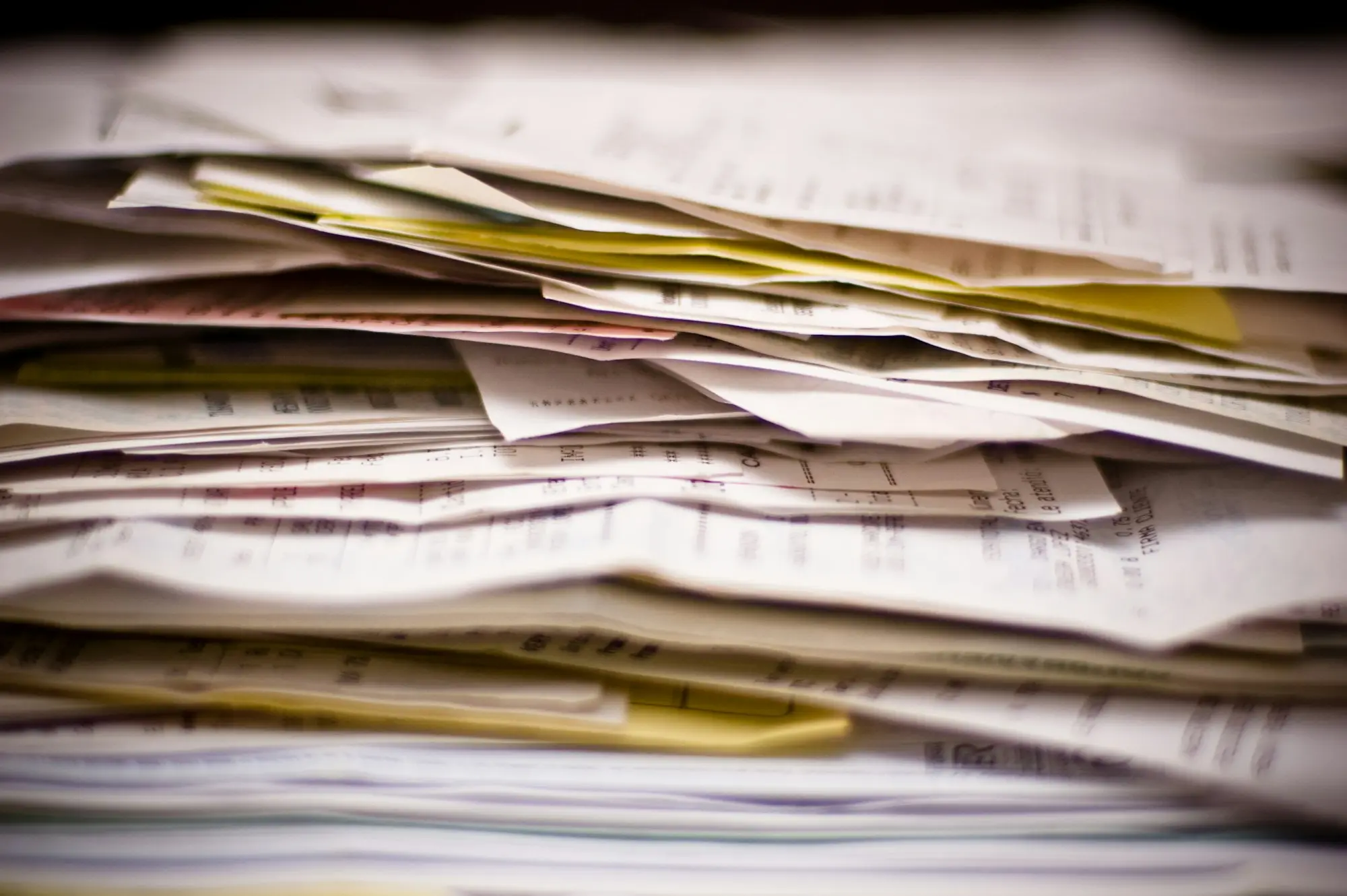 Stack of unpaid invoices and paperwork that invoice finance turns into cash