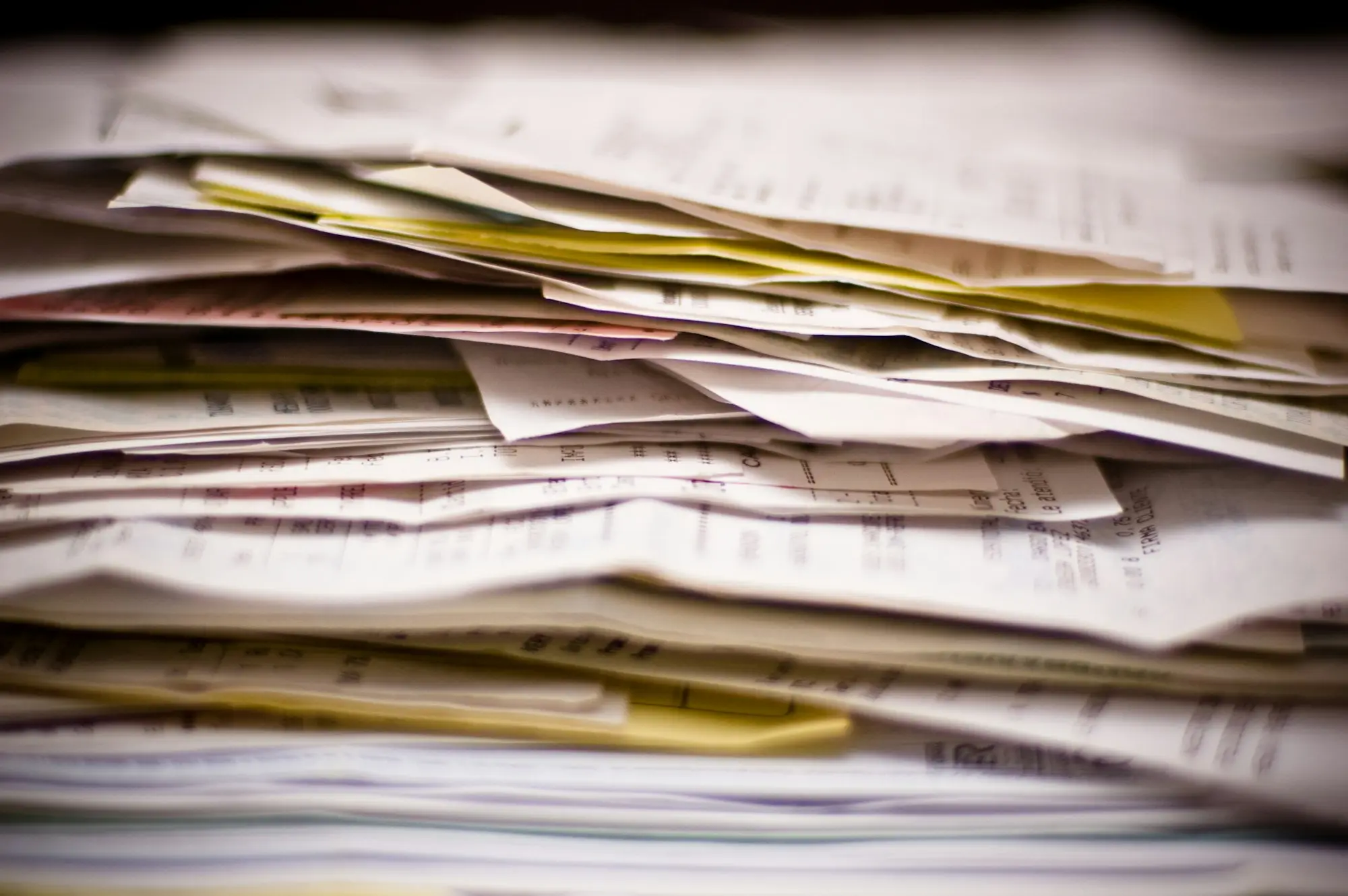 Stack of unpaid invoices and paperwork that invoice finance turns into cash