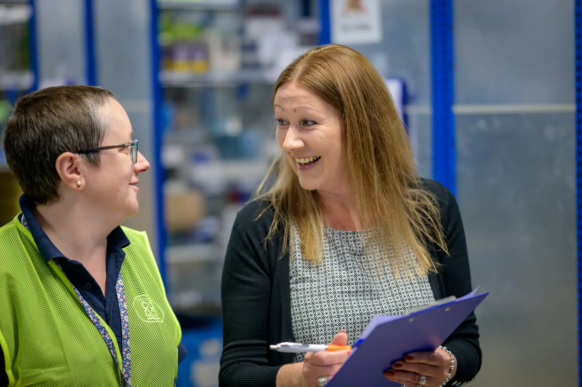 Labour hire site supervisor checking worker timesheets on a clipboard, the records behind invoice finance for labour hire