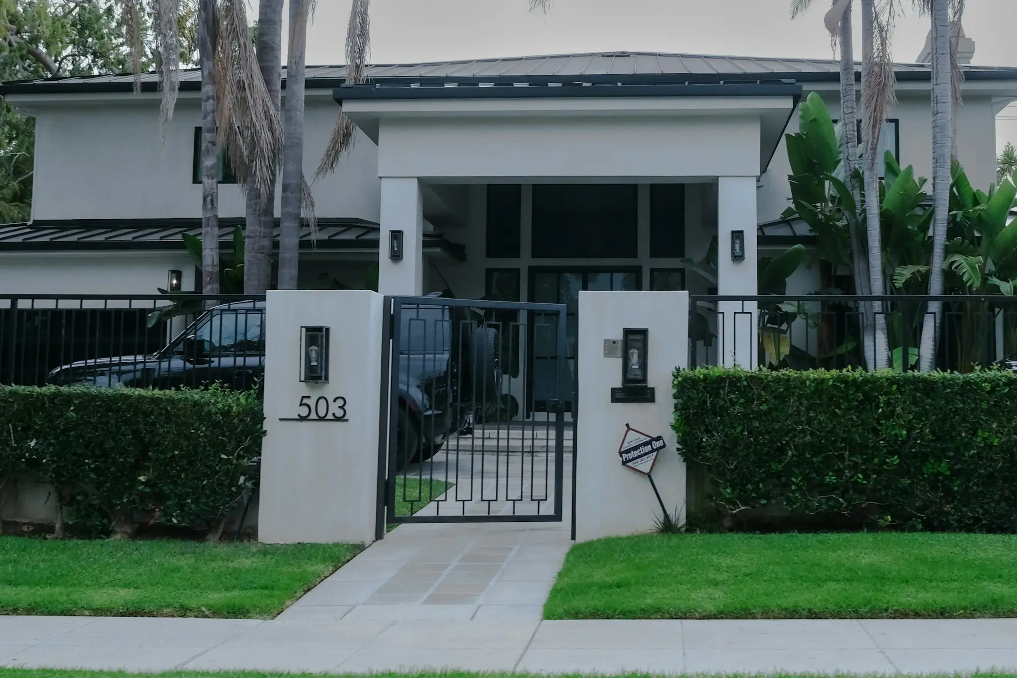 Business owner standing at the front gate of his family home, thinking about whether a business loan could put the house at risk