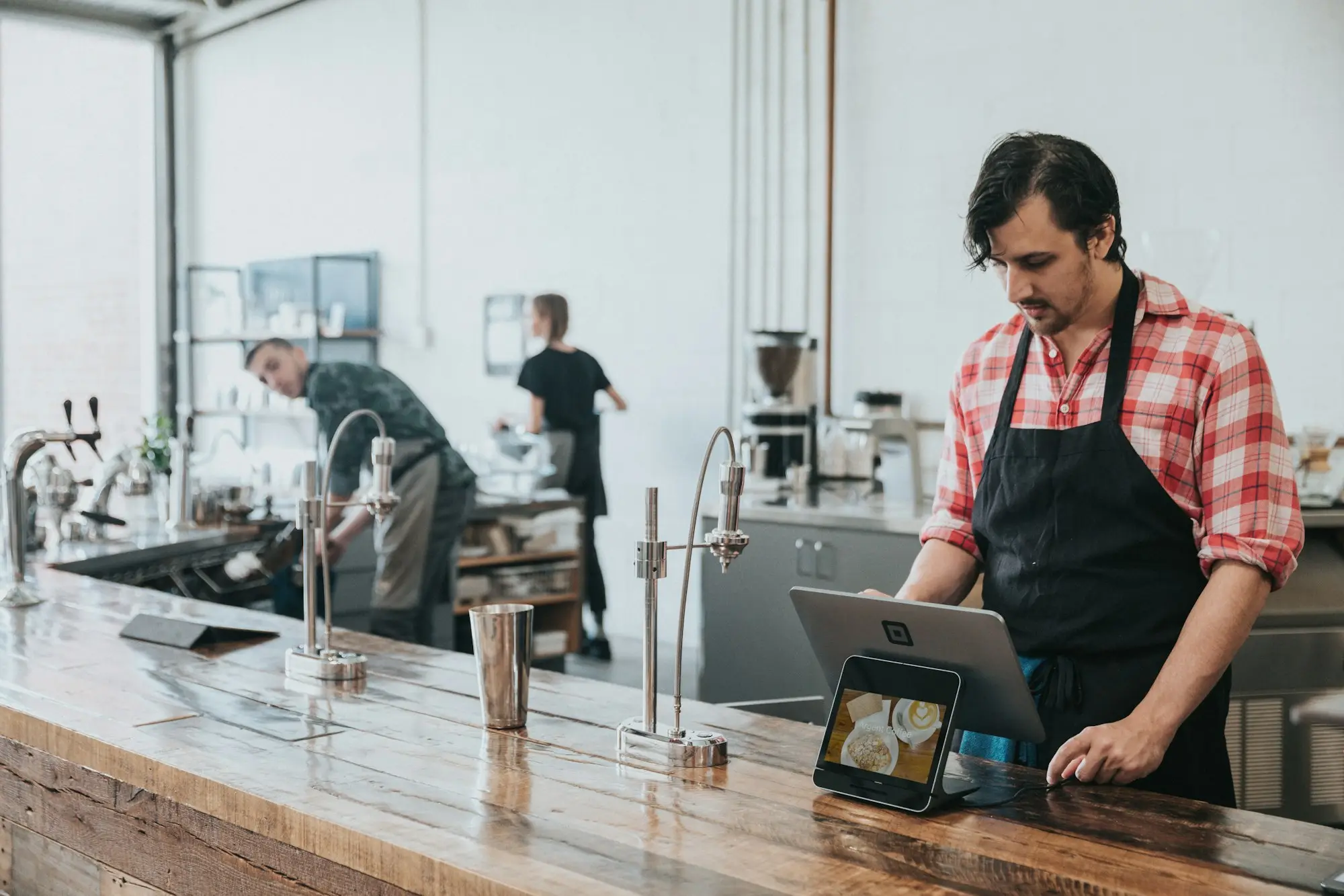 Cafe owner at the counter with a laptop preparing a low doc loan application with only one or two BAS lodged
