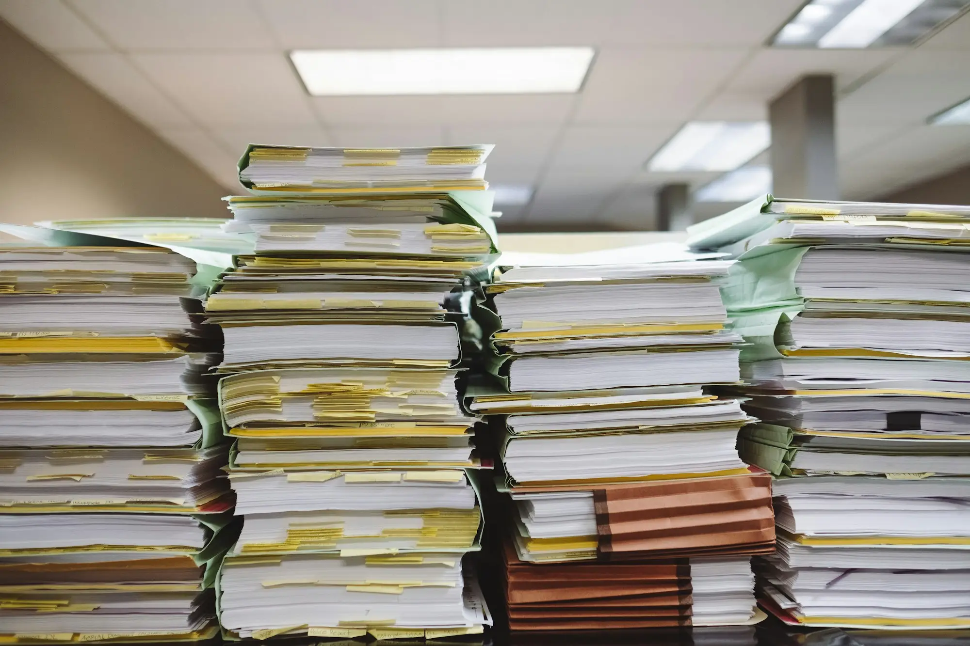 Practice manager sorting paperwork at a clinic reception desk, preparing documents for medical equipment finance