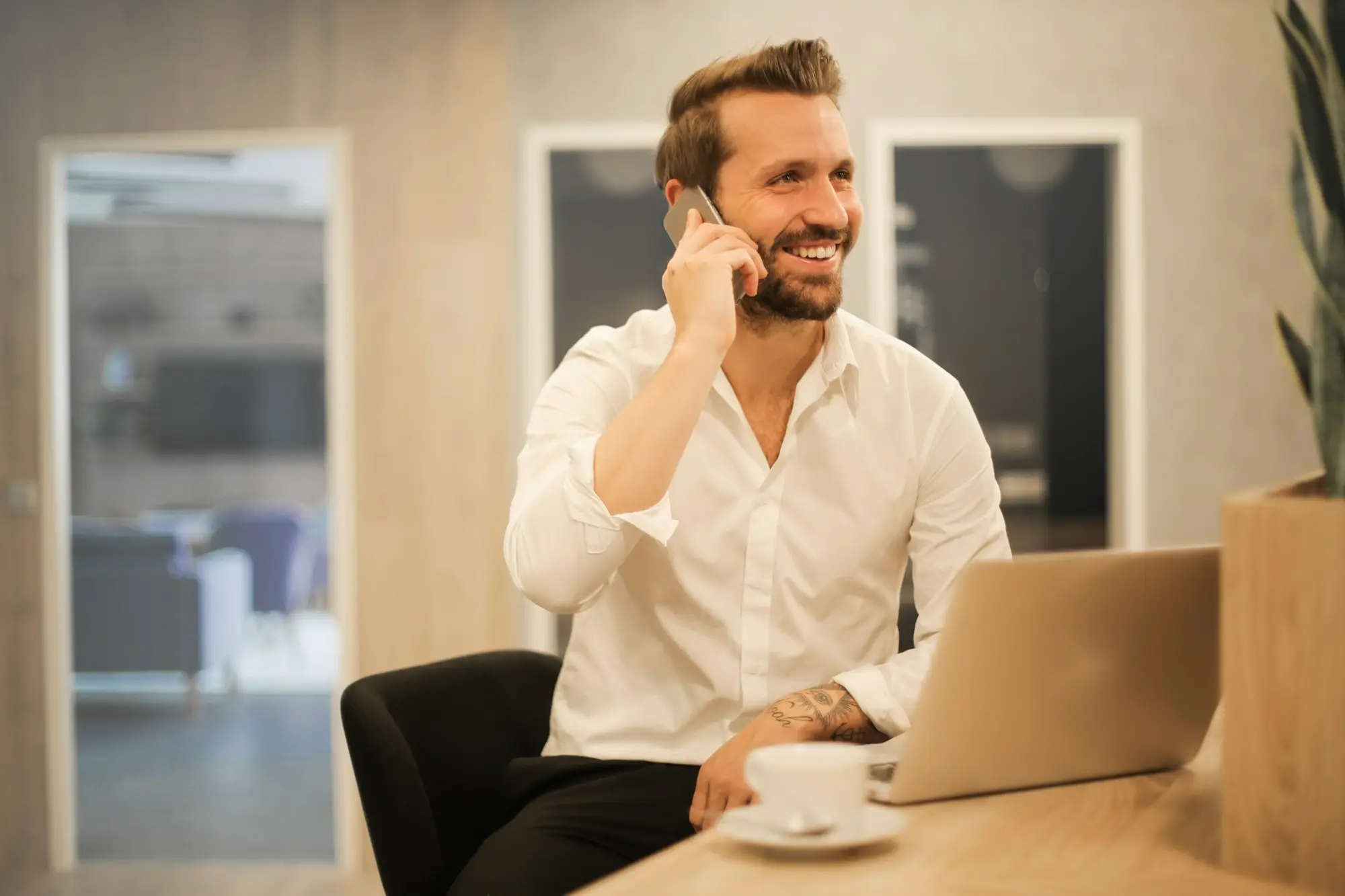 Small business owner on the phone to a lender after missing a line of credit repayment, with an overdue invoice in hand