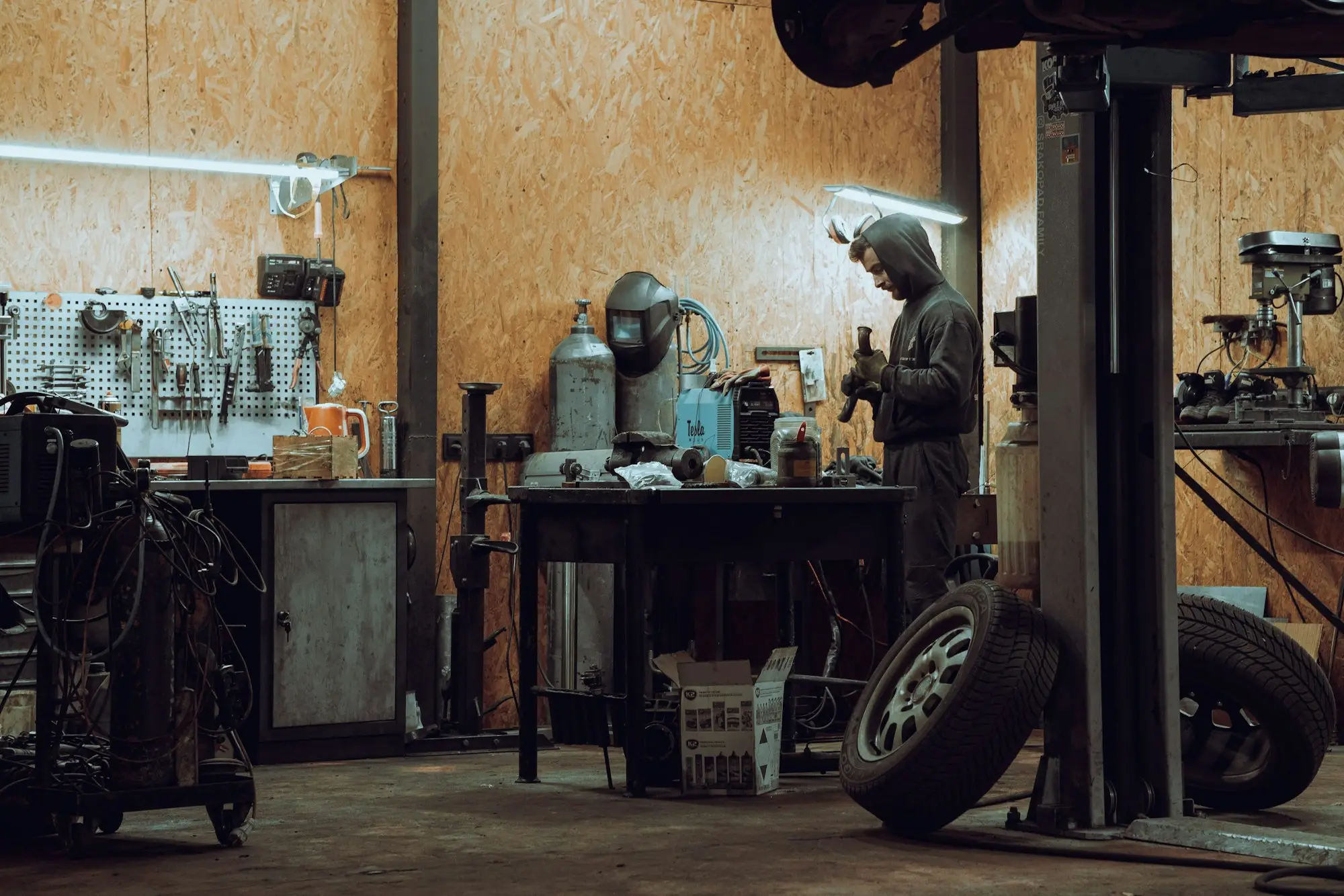 Mechanic workshop owner at a laptop in the office planning the switch of a business overdraft to a new lender