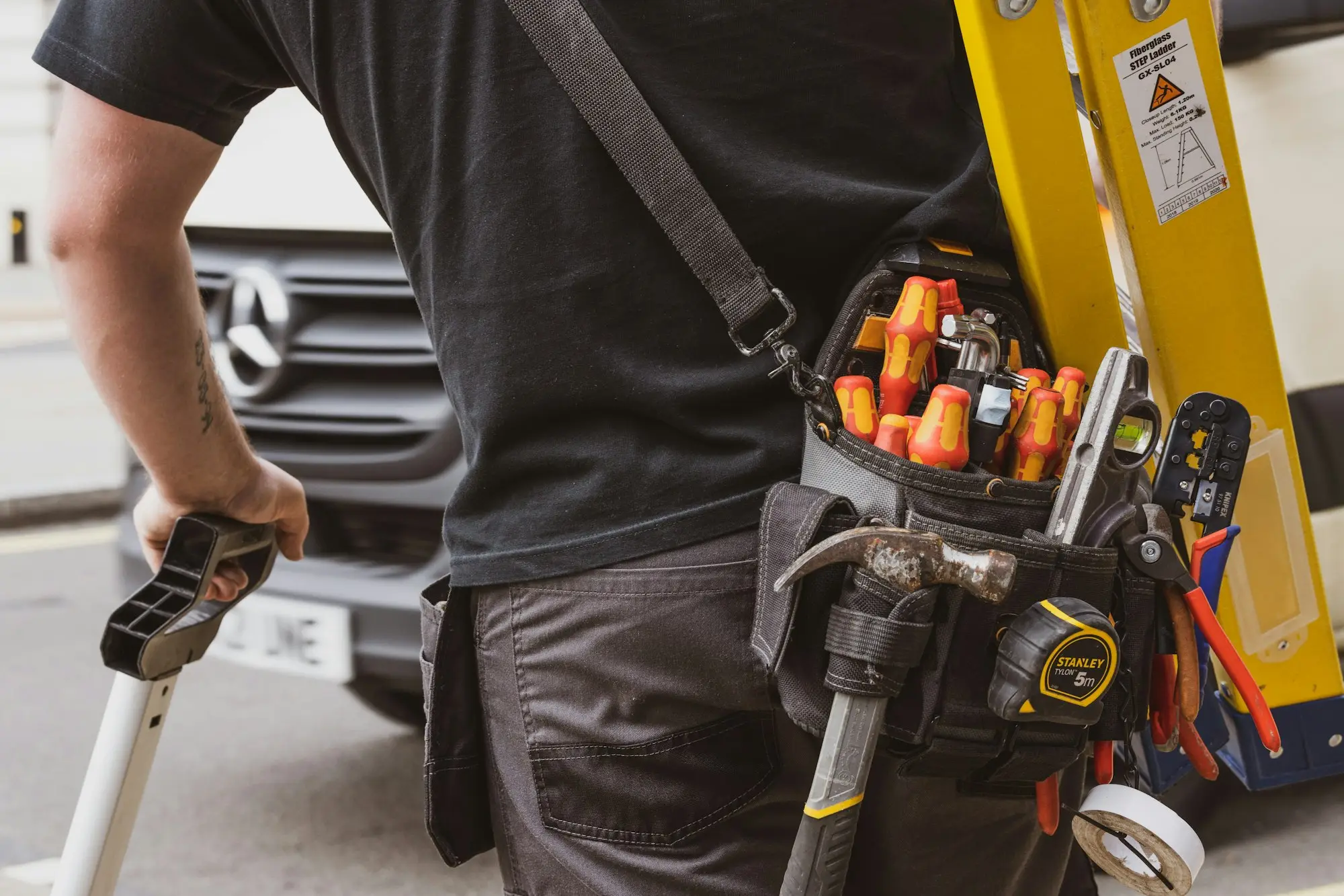 Electrician loading tools into a work ute after leaving a job to start a new business with a startup loan