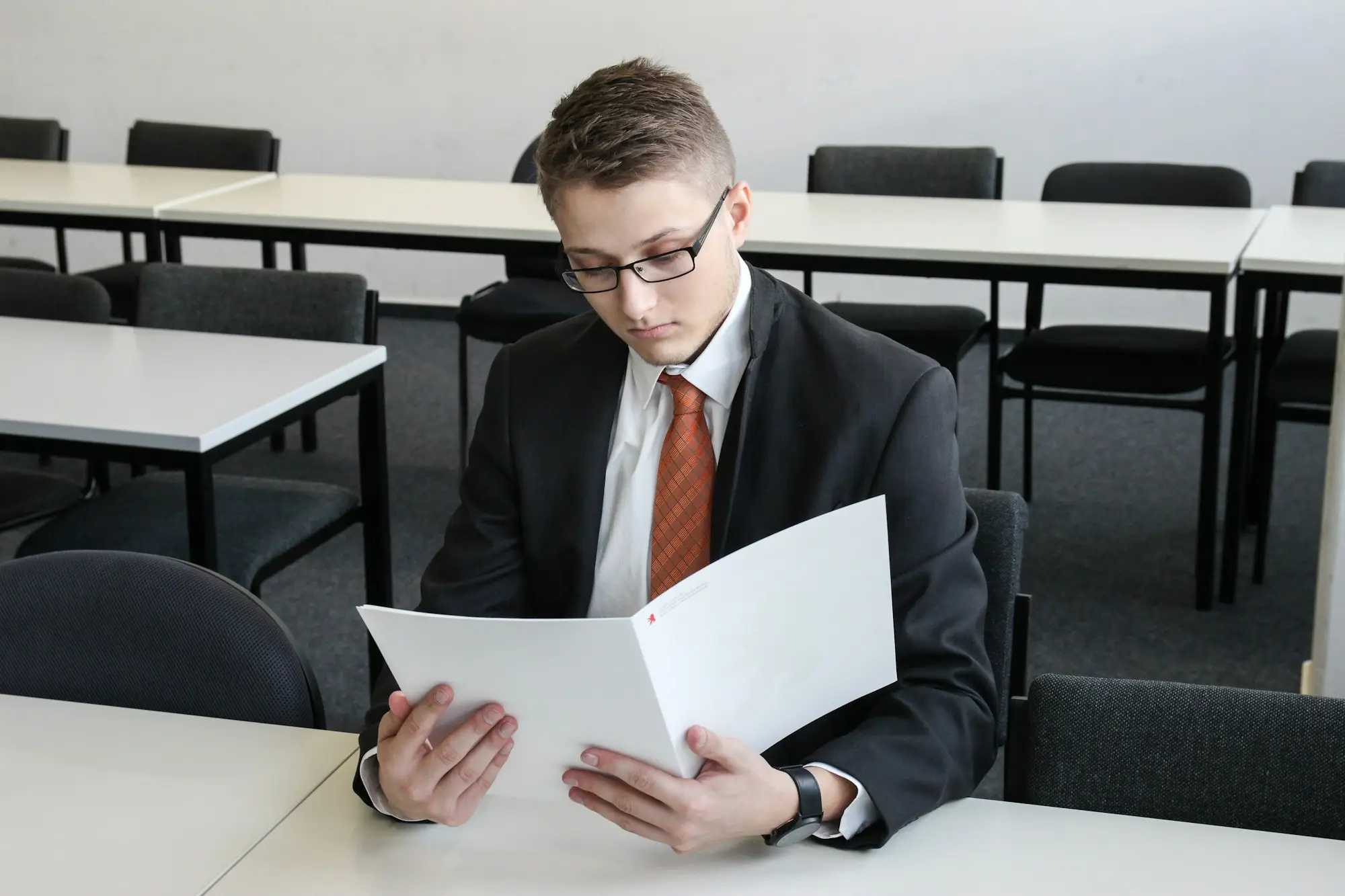 Workshop owner reading a settlement statement to compare the gross loan with the net advance on a private business loan