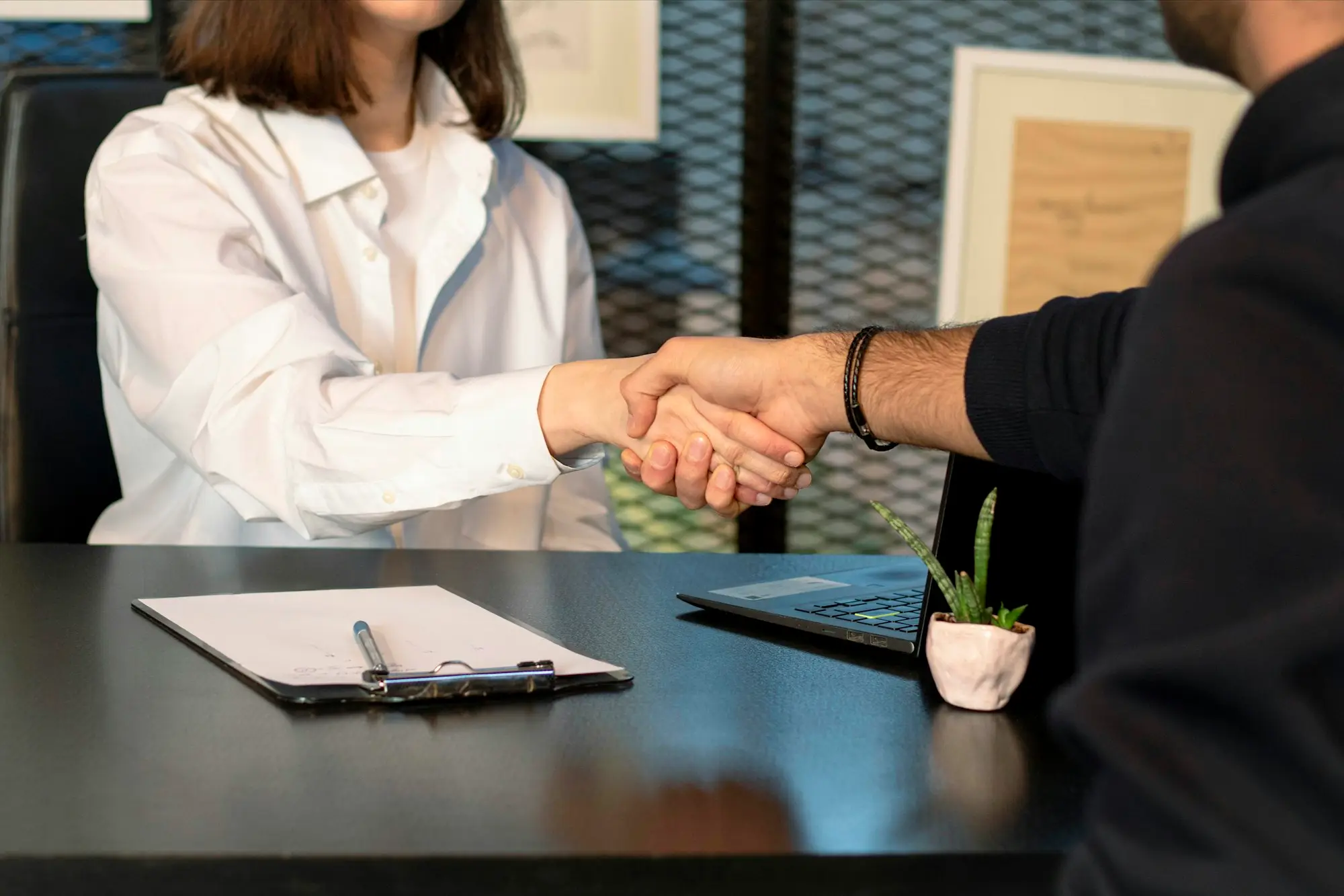 Business owner and private lender shaking hands across a meeting table