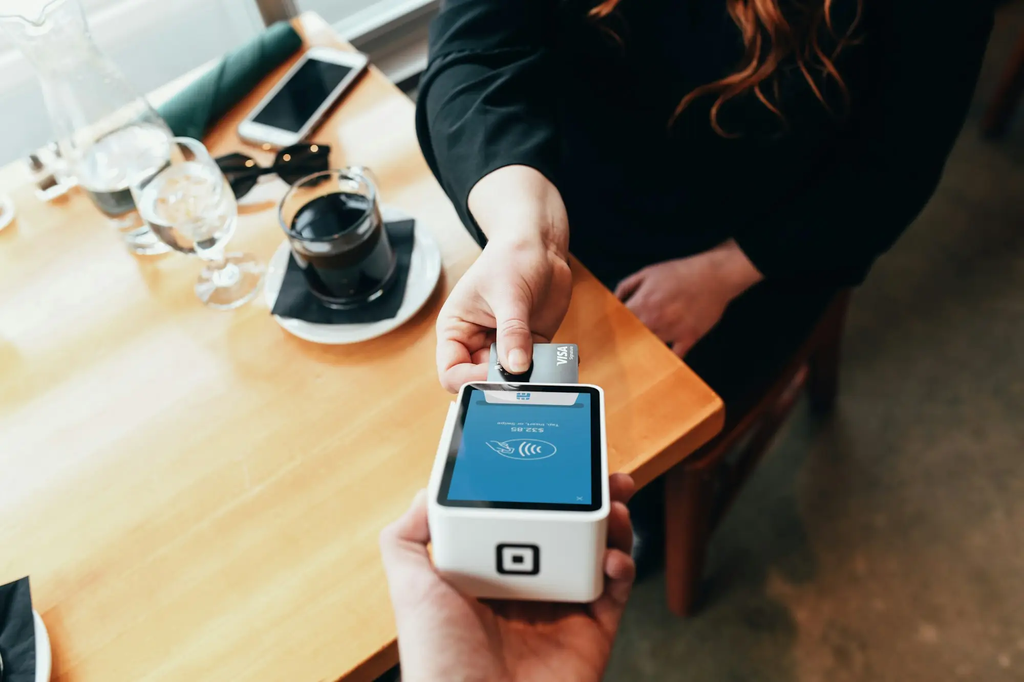Customer tapping a card on a payment terminal, the takings revenue-based finance is repaid from