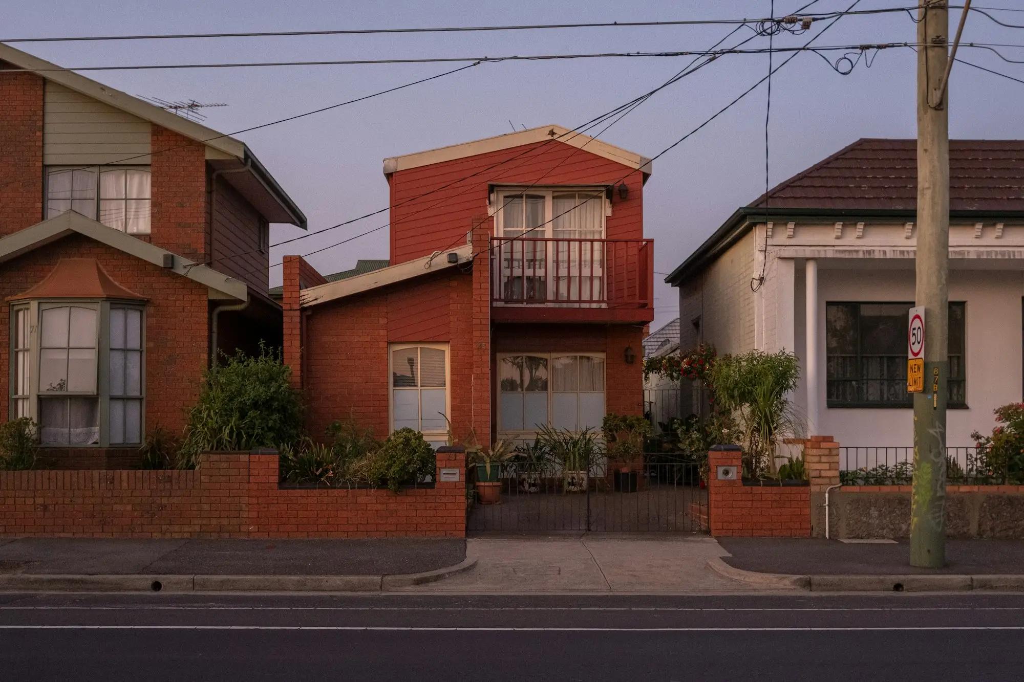 Row of newly completed townhouses on a suburban street, as the developer decides whether to sell or hold and refinance some of the finished stock