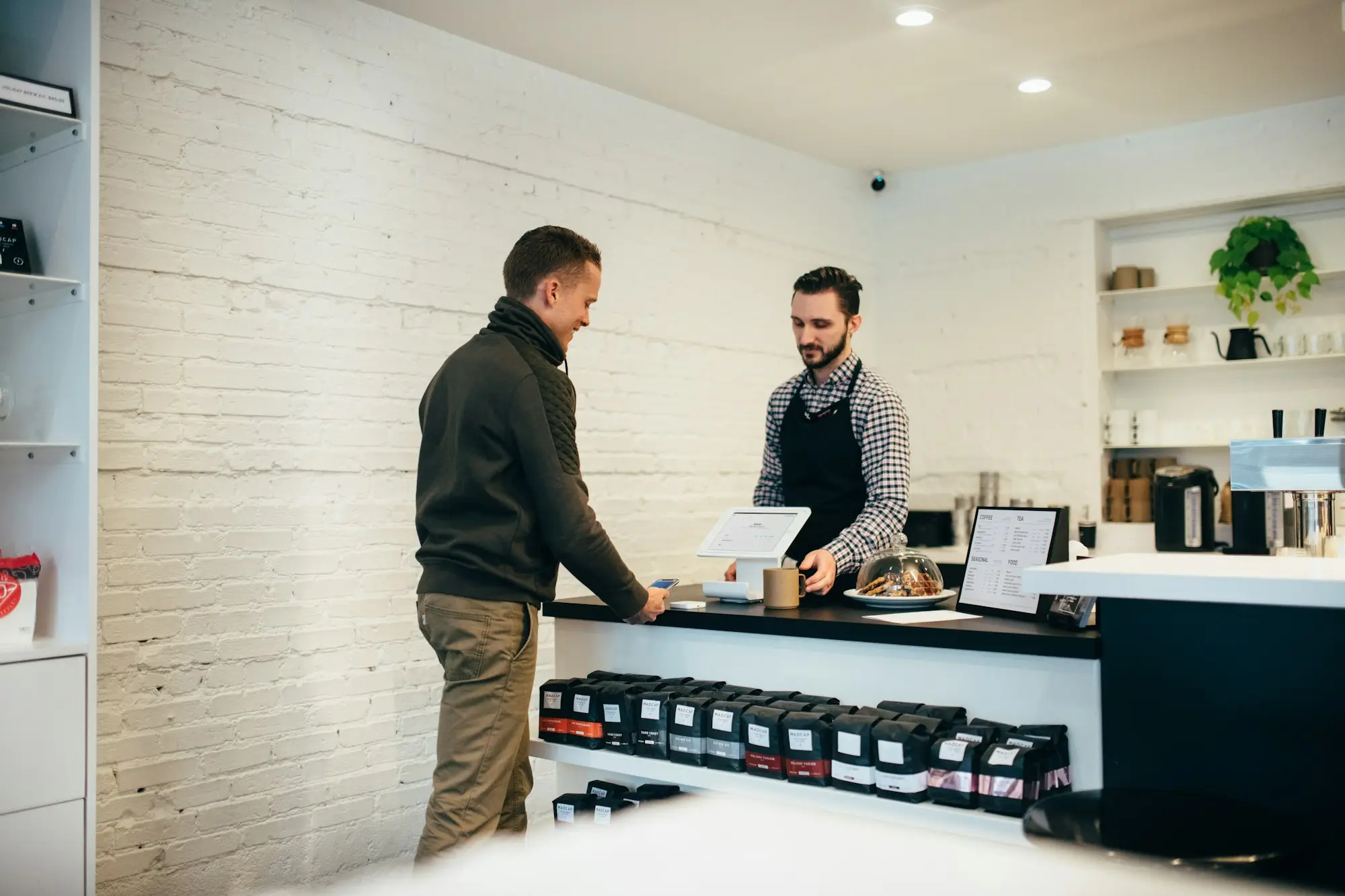 Café owner handing shop keys to a buyer after selling a business with an EFTPOS advance paid out at settlement