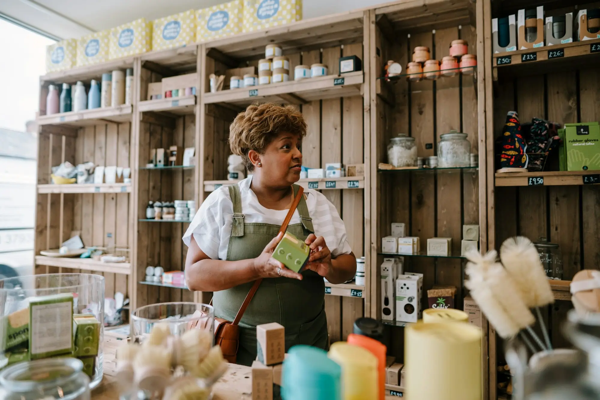 Shop owner arranging stock on shelves, a quick need often covered by a short-term business loan
