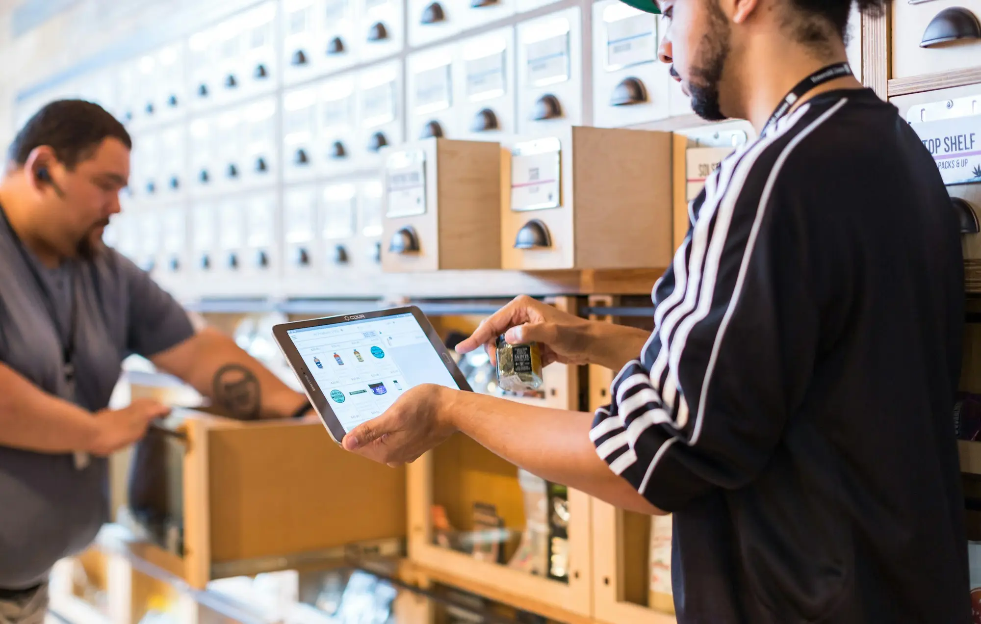 Wholesaler checking inventory levels on a tablet in a warehouse to calculate stock turnover before a business loan application