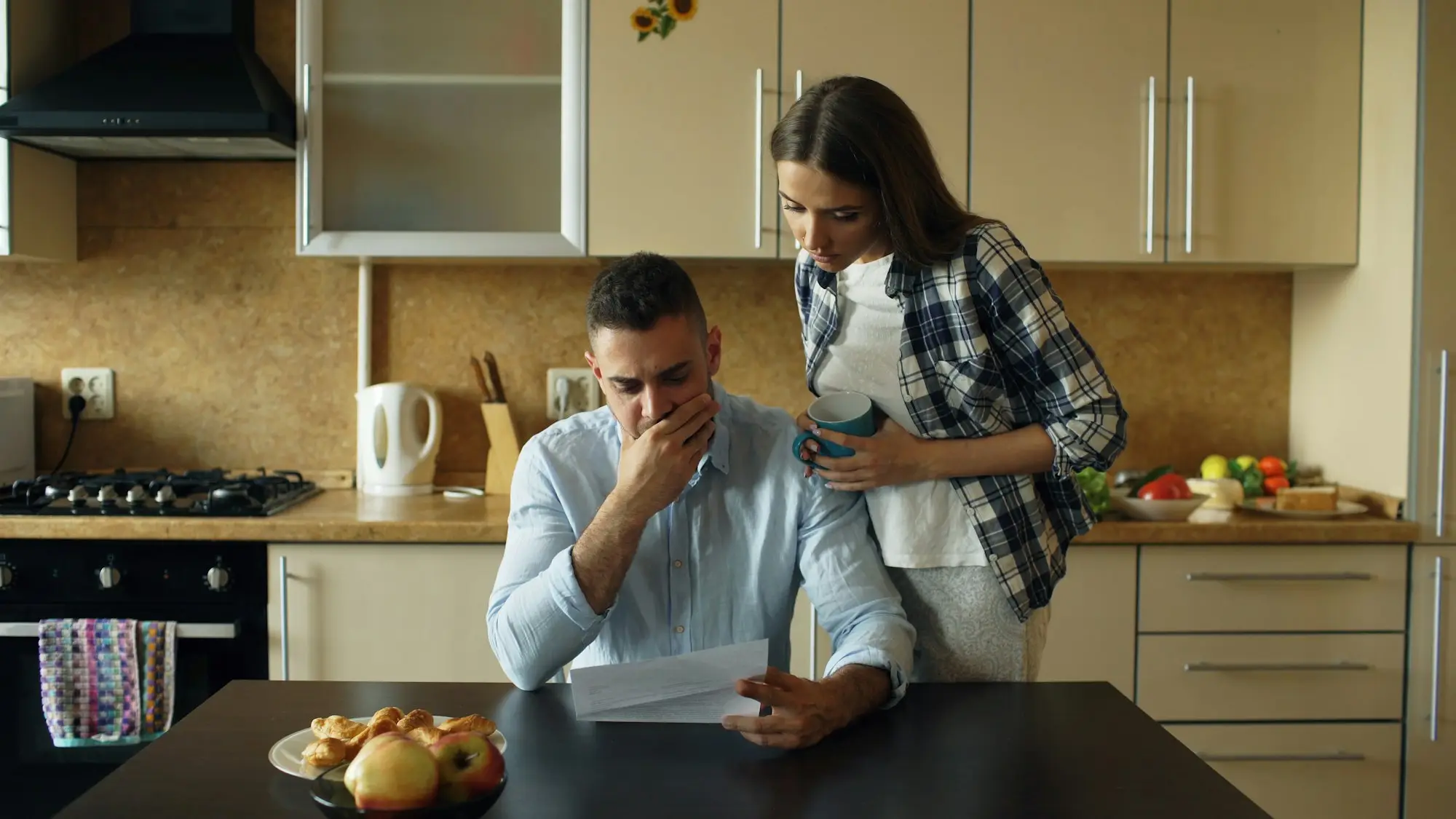 Business-owning couple reviewing overdue business bills and weighing super against home equity to pay them