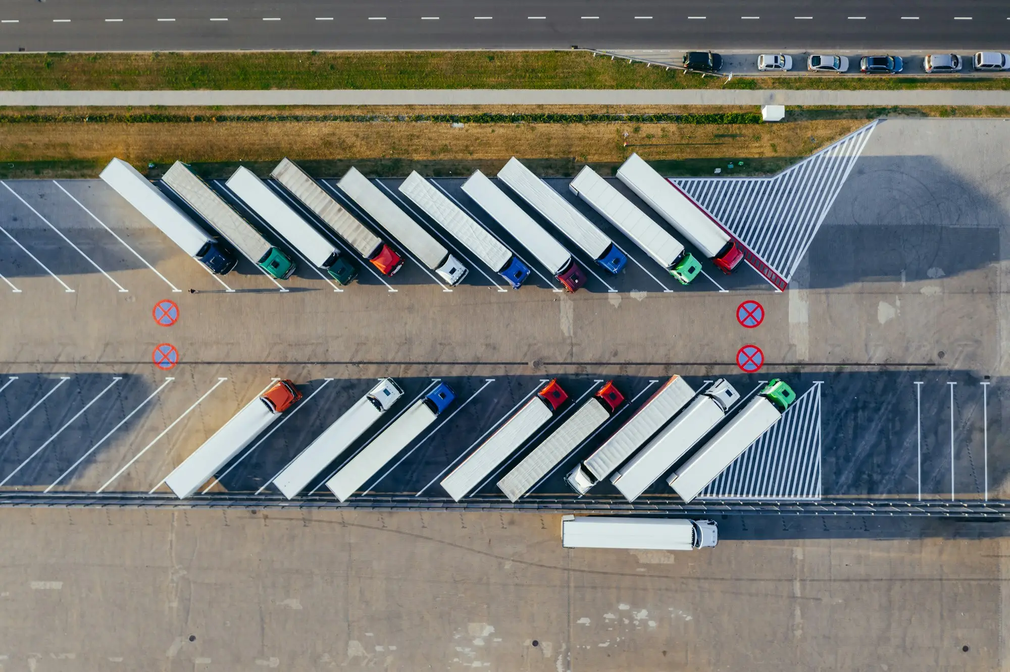 Rigid trucks backed up to a freight depot loading dock, the kind of contracted work that supports truck finance