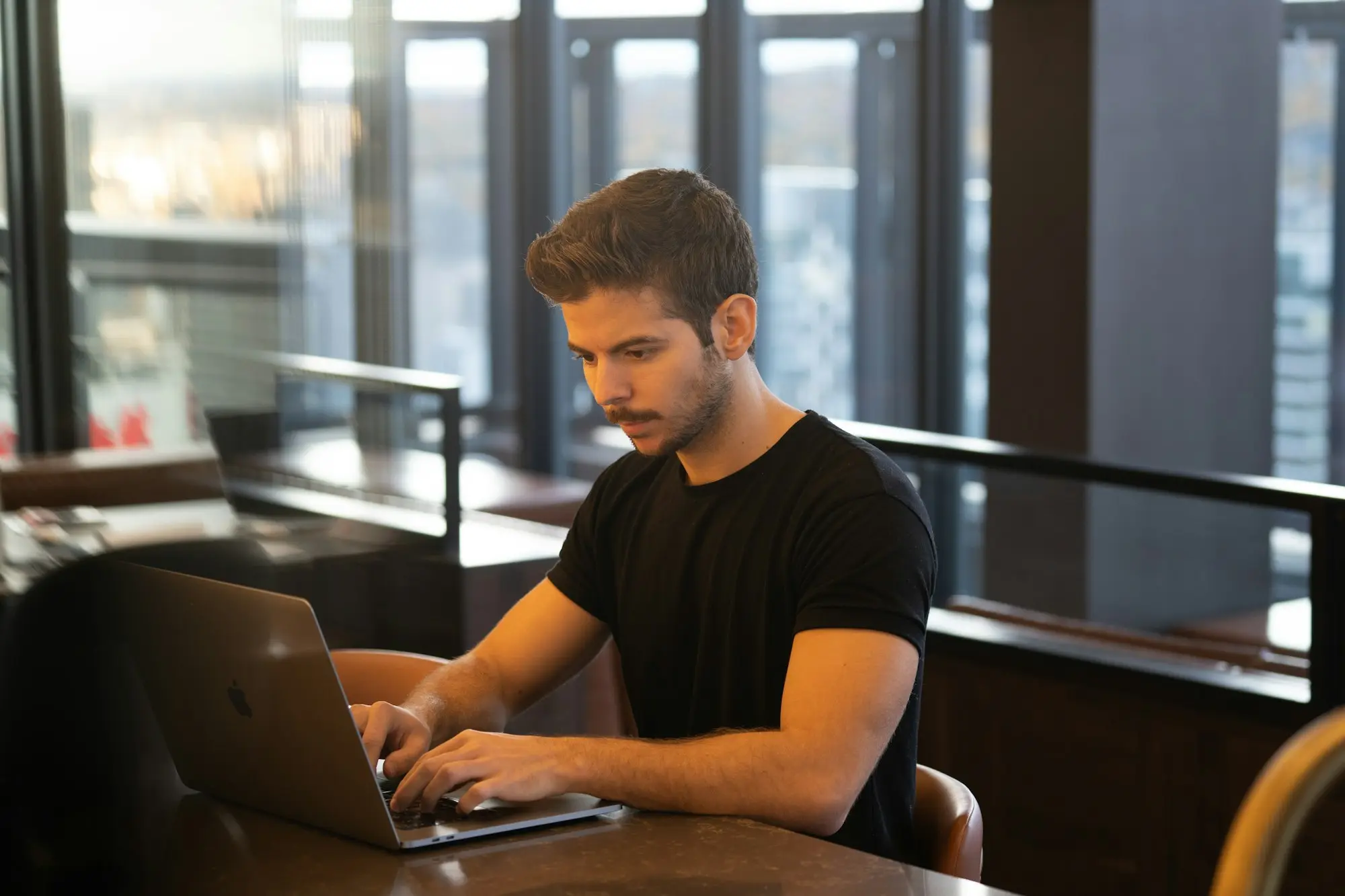 Business owner working across two laptops while managing the finances of two businesses for an unsecured loan