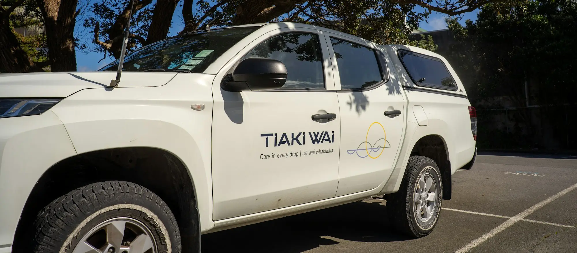 Sole-trader tradie checking a personal bank account on his phone beside his ute while preparing an unsecured business loan